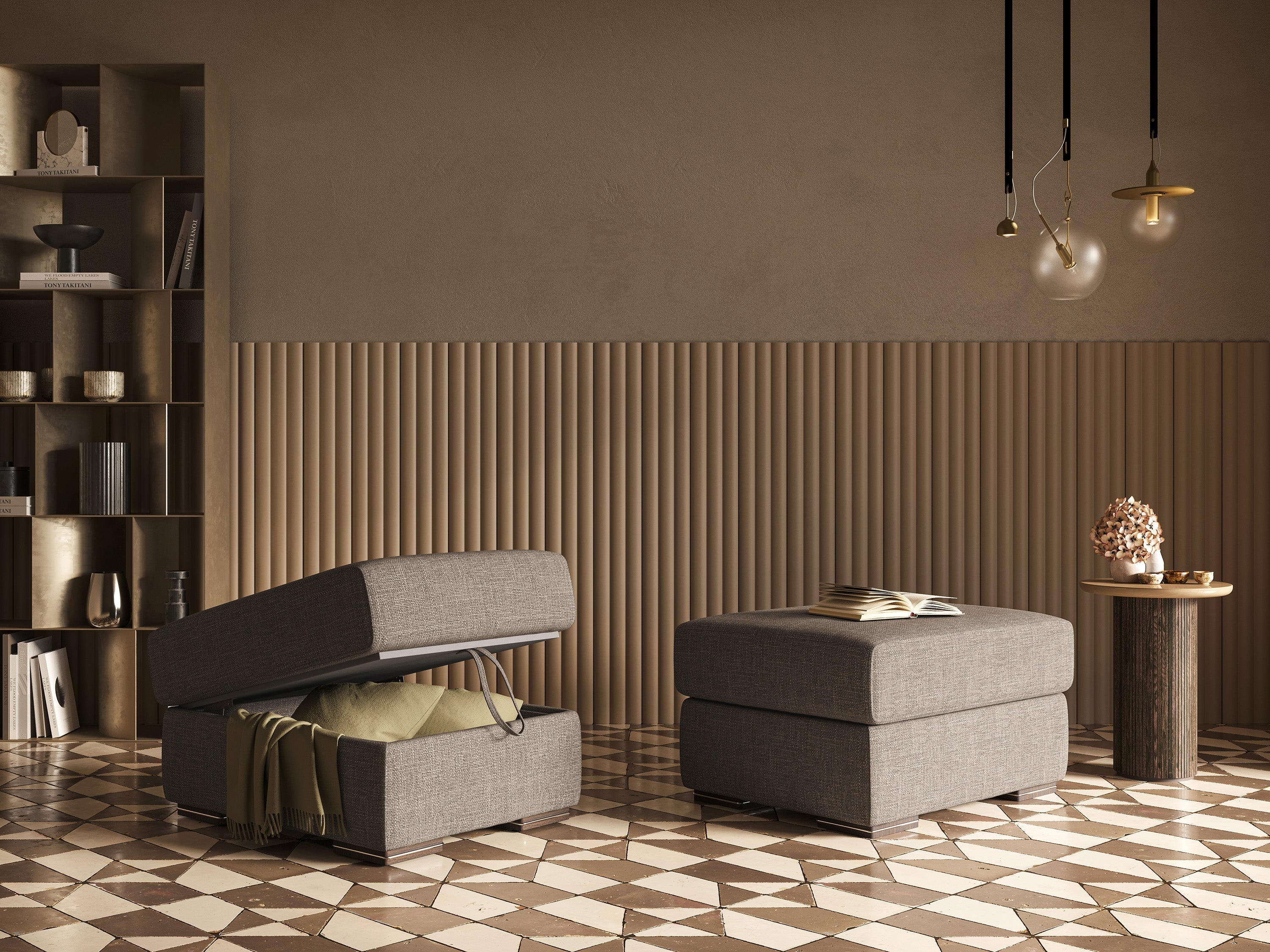 Un soggiorno moderno con due pouf grigi, uno dei quali aperto per mostrare le coperte riposte all'interno. Vicino c'è un tavolino rotondo con un vaso e dei libri. Piastrelle geometriche sul pavimento e pareti dai toni neutri completano l'arredamento.