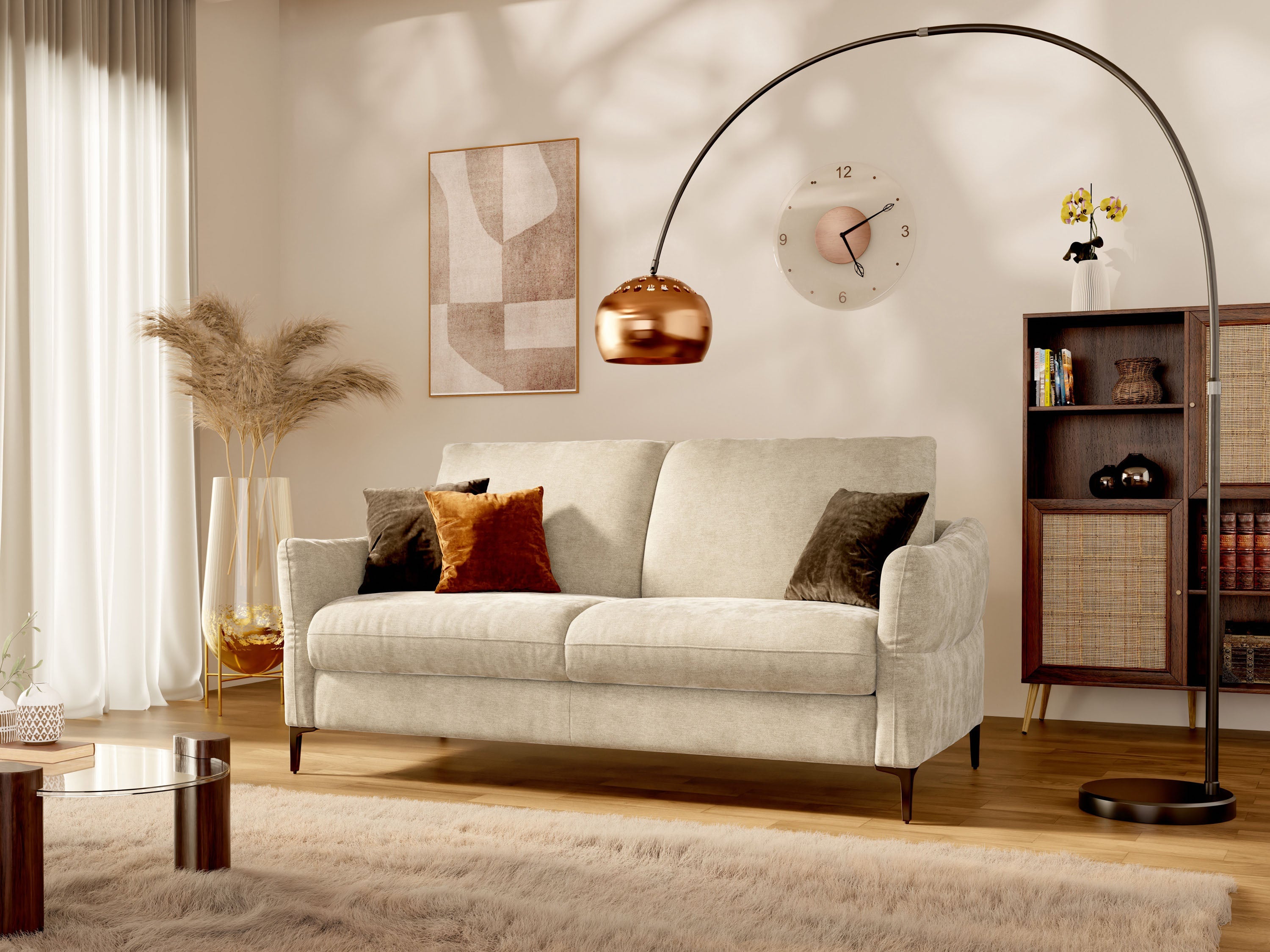 Un accogliente soggiorno con un divano beige, cuscini assortiti, una moderna lampada da terra ad arco, un orologio da parete, opere d'arte astratte, una libreria, erba della pampa in un vaso e luce del sole che filtra attraverso tende trasparenti.