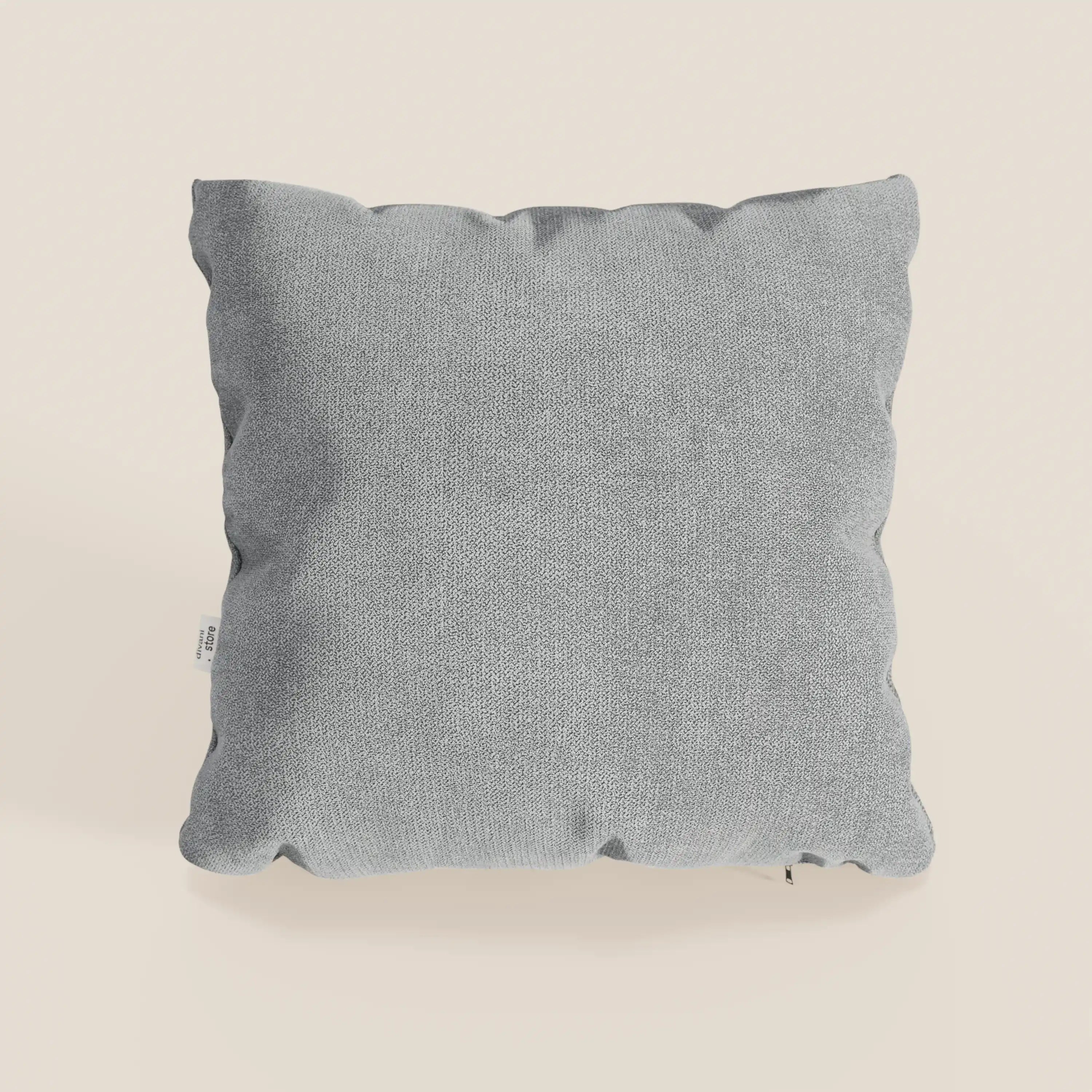 Il cuscino Destiny di Divani.Store, 45x45 cm in morbido tessuto impermeabile grigio chiaro T02, ha una forma quadrata con angoli leggermente arrotondati e una piccola etichetta bianca sulla cucitura sinistra, su sfondo bianco sporco.