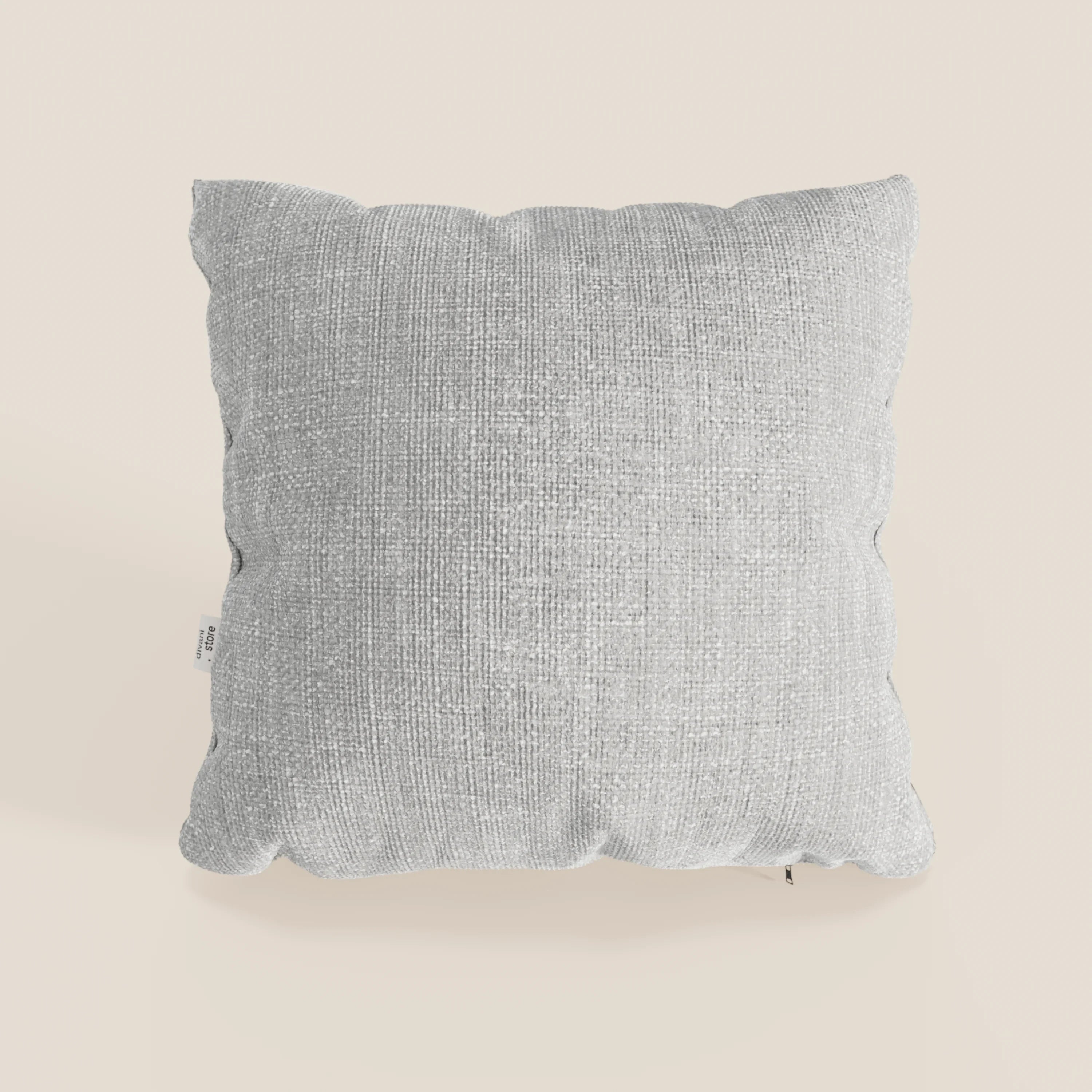 Il cuscino Lyon 45x45 cm di Divani.Store, in intrecciato impermeabile T06 grigio, è caratterizzato da bordi morbidi e arrotondati e da una piccola etichetta laterale bianca, su sfondo bianco sporco.