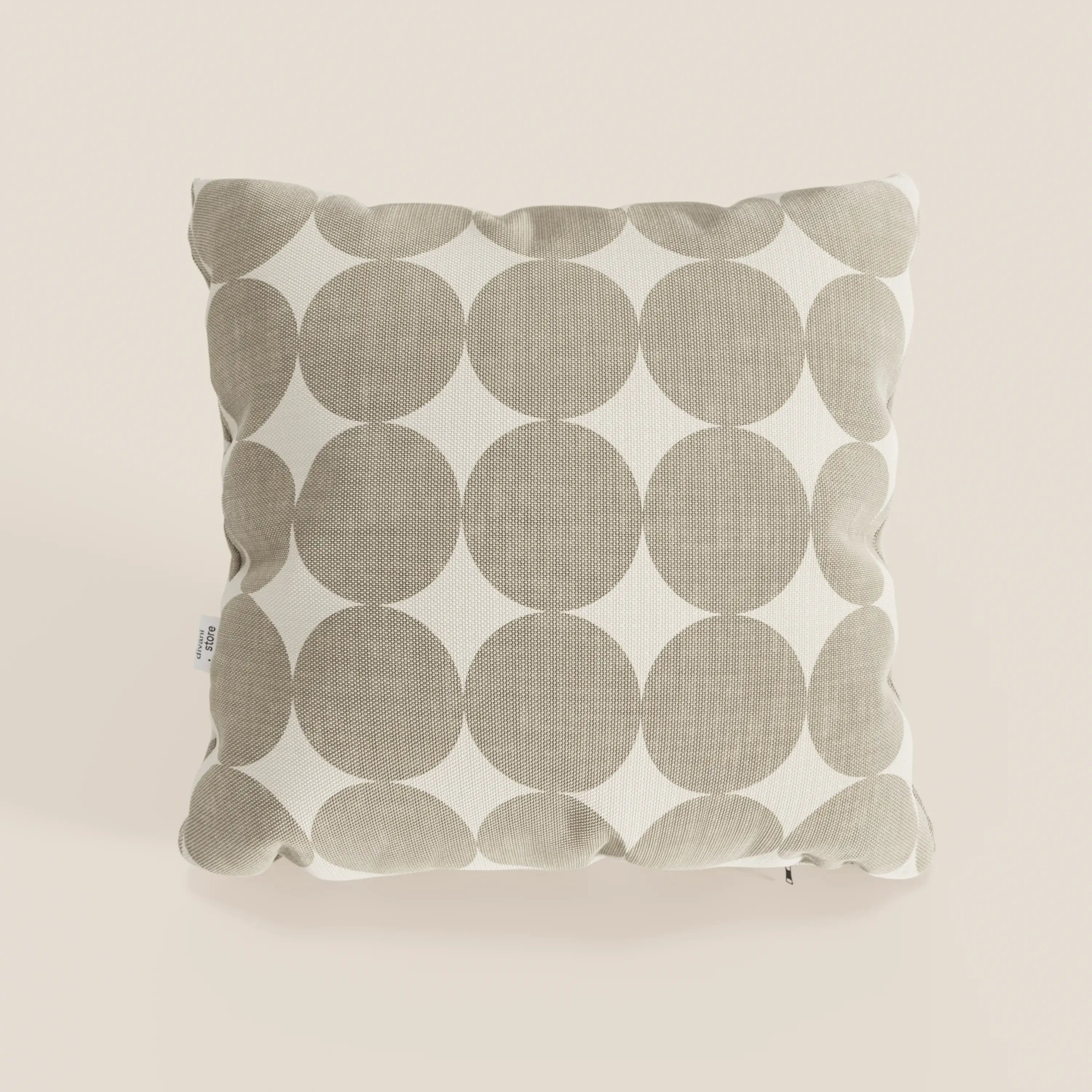Il cuscino Dot cuscini geometrici di Divani.Store è un cuscino quadrato in tessuto idrorepellente beige, con motivo geometrico a cerchi bianchi, superficie morbida e strutturata, cuciture a vista ed etichetta in tessuto sul bordo sinistro.