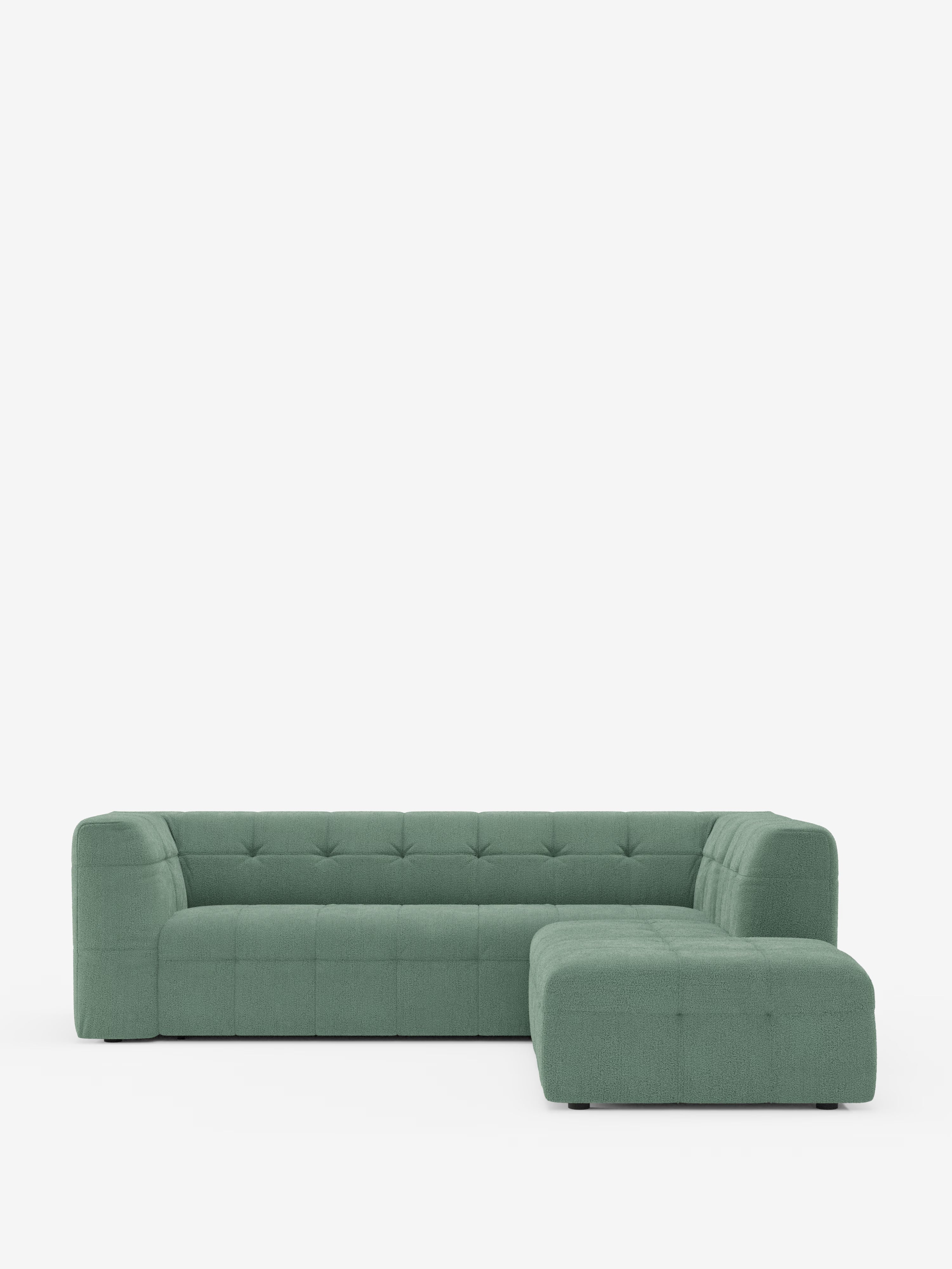 Un divano componibile a L dal design contemporaneo ed ecologico — il divano angolare componibile e modulare Mosaic in bouclé di Divani.Store — spicca su uno sfondo bianco a tinta unita. Questo divano presenta cuscini capitonné, braccioli bassi e squadrati ed è rivestito in tessuto T21 antimacchia; le sue linee pulite e il design minimalista lo rendono l’elemento perfetto per qualsiasi soggiorno moderno.