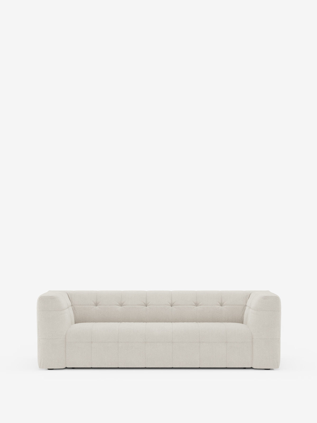 Un moderno divano modulare Mosaic a 3 e 4 posti dal profilo slanciato, realizzato in bouclé: capitonné e design in tessuto antimacchia T21 di Divani.Store, è messo in risalto su uno sfondo bianco a tinta unita. Il design minimalista è caratterizzato da linee pulite, cuscini trapuntati, ampi braccioli e un morbido tessuto antimacchia.