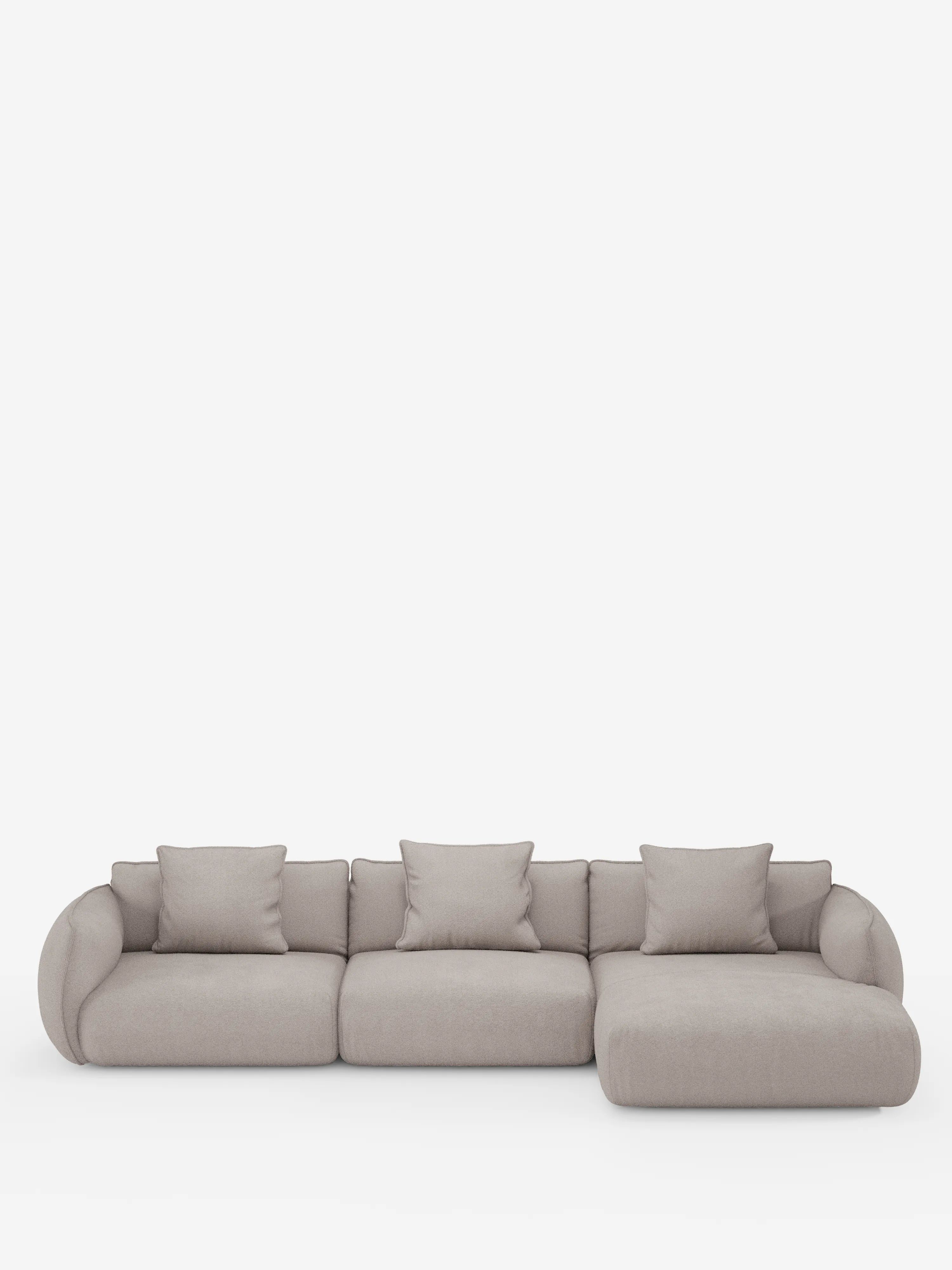 Un moderno divano angolare Nimbus con penisola componibile, realizzato in morbido tessuto effetto cotone lavabile T33 di Divani.Store, caratterizzato da una finitura grigio chiaro, bordi arrotondati, tre cuscini di seduta, una chaise longue sul lato destro e quattro cuscini decorativi coordinati. Il divano in stile contemporaneo è esposto su uno sfondo bianco a tinta unita.