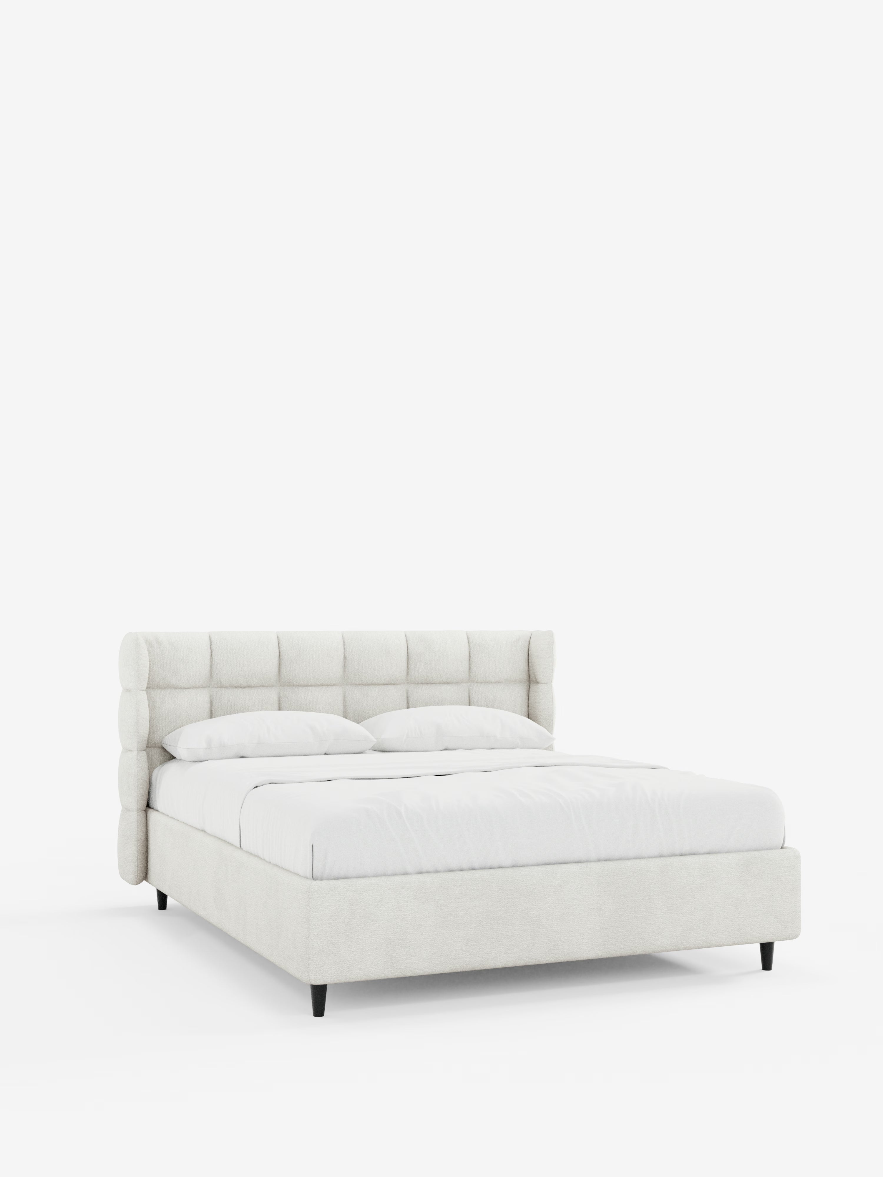 Il letto imbottito RAGNAR con contenitore e testiera capitonné avvolgente di Letti.store si caratterizza per un design elegante e dal profilo basso, in beige chiaro, rivestito con tessuto certificato Oeko-Tex®. Con la biancheria da letto e i cuscini bianchi che lo impreziosiscono, questo letto poggia su corte gambe nere su uno sfondo bianco a tinta unita.