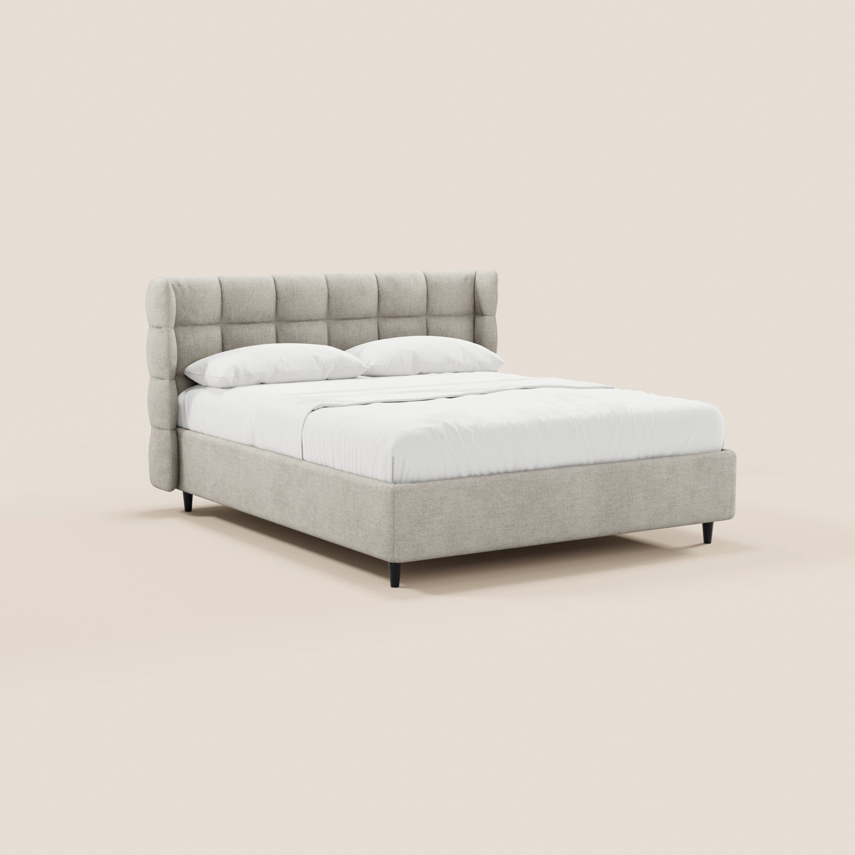 Il letto imbottito RAGNAR di Letti.store è caratterizzato da una testiera alta e avvolgente con finitura capitonné e da gambe corte di colore nero. Rivestito con un elegante tessuto grigio chiaro certificato Oeko-Tex®, si distingue su uno sfondo beige a tinta unita, creando un look pulito e minimalista.