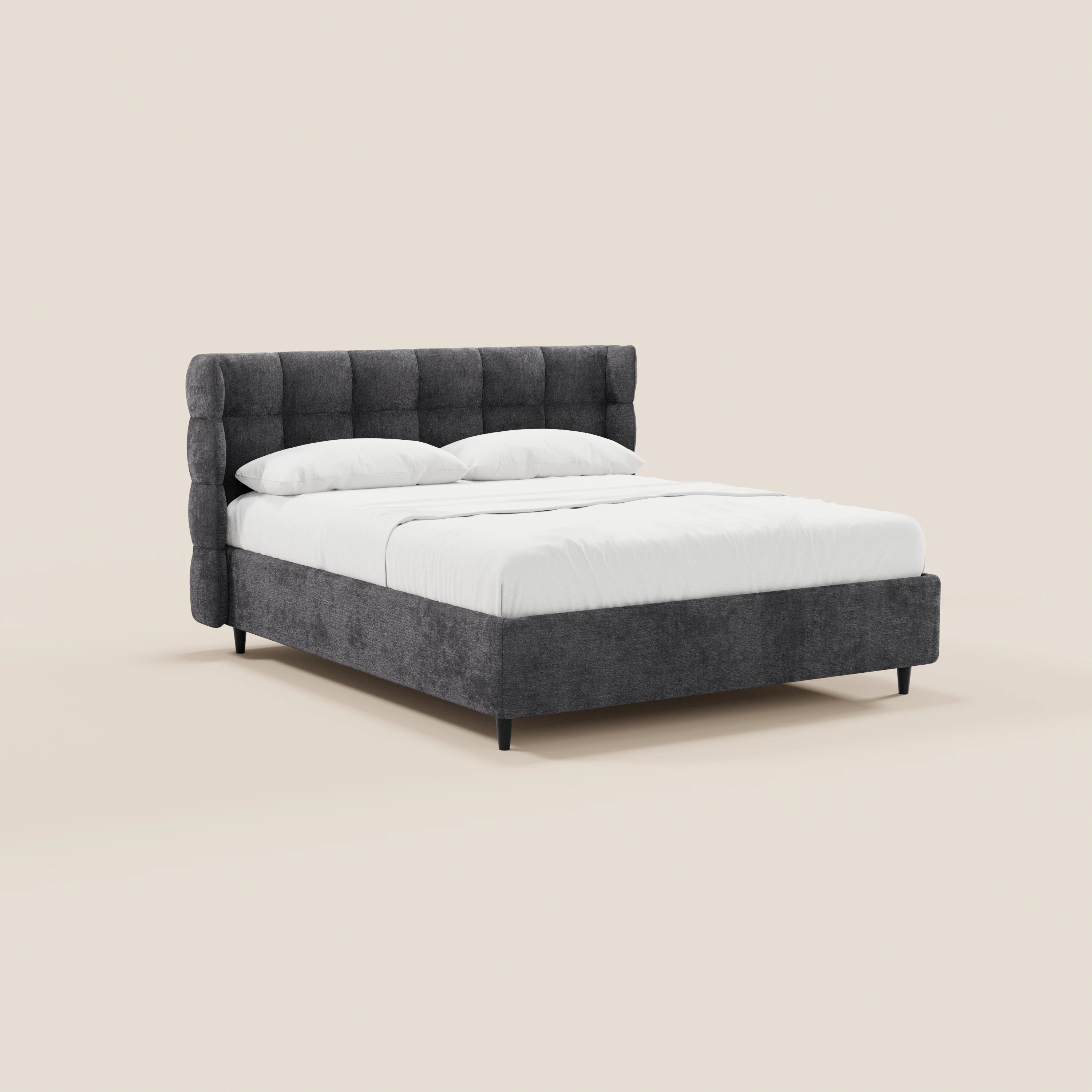Il letto imbottito RAGNAR di Letti.store presenta una testiera avvolgente capitonné, sottili gambe nere, un elegante tessuto grigio scuro certificato Oeko-Tex®, biancheria da letto bianca e quattro cuscini, il tutto su uno sfondo beige chiaro in stile minimalista.