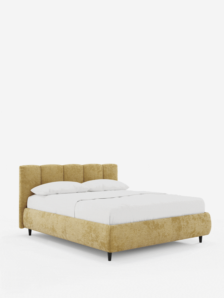 Il letto imbottito ARKAM con contenitore e testiera a pannelli verticali è un letto dal profilo basso, di colore giallo senape, con testiera a pannelli verticali, gambe affusolate scure e lenzuola bianche immacolate su uno sfondo bianco.