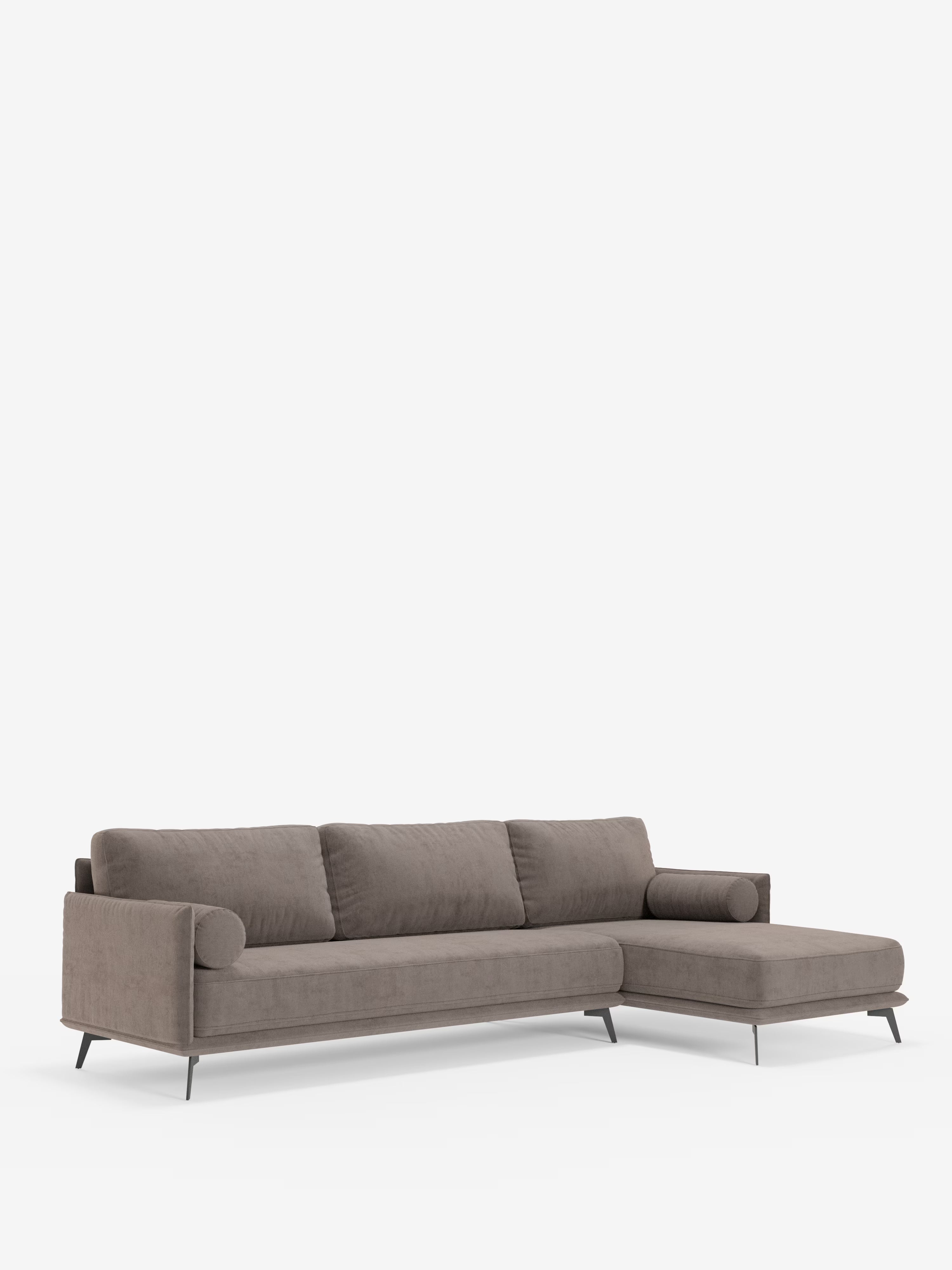 Il divano moderno angolare con penisola Basalto di Divani.Store presenta un design contemporaneo in tessuto color taupe con tre cuscini di seduta, tre cuscini dello schienale imbottiti in piuma e rivestiti in tessuto T31 antimacchia, braccioli arrotondati ed eleganti gambe in metallo nero. La sezione chaise longue si estende verso destra, sottolineandone la versatilità moderna e l’estetica elegante su uno sfondo bianco a tinta unita.