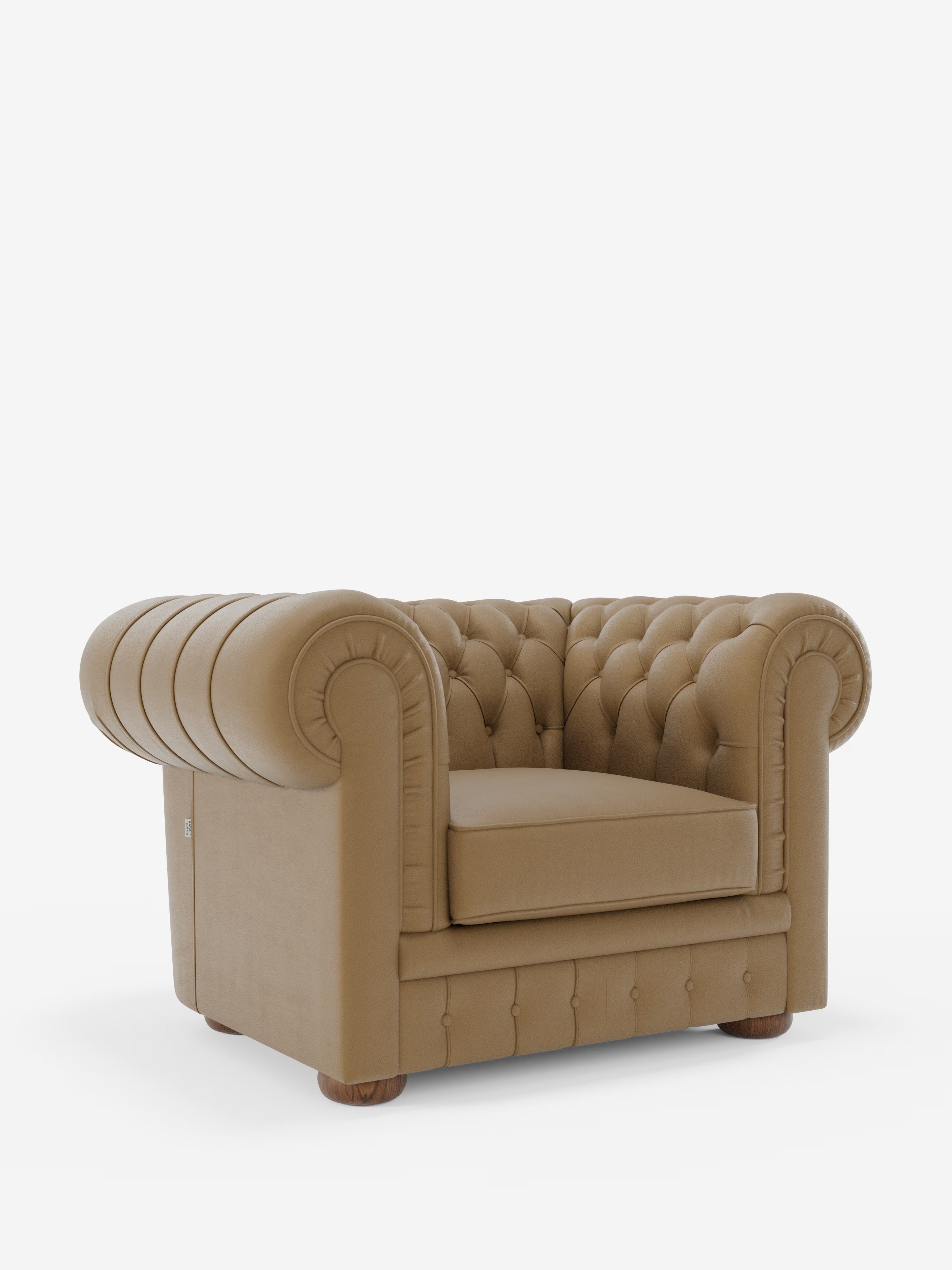 Una poltrona Chester in vera pelle spessorata con capitonné artigianale di Divani.Store, caratterizzata da una profonda trapuntatura a bottoni, braccioli arrotondati e un unico cuscino di seduta — realizzata con maestria e cura artigianale — poggia su corte gambe in legno su uno sfondo bianco a tinta unita.