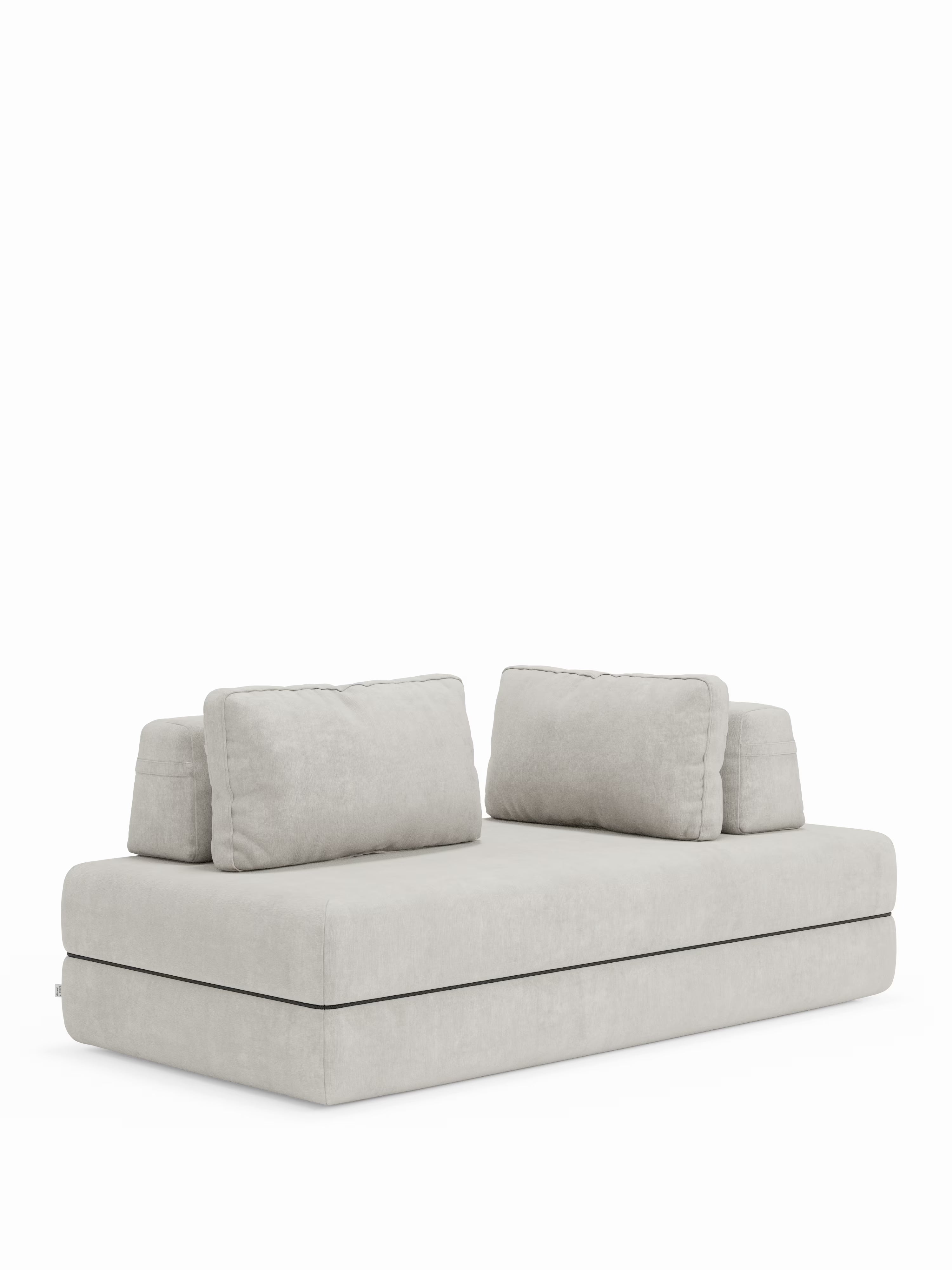 Un moderno divano letto matrimoniale Rift a 2 e 3 posti di Divani.Store, qui presentato in grigio chiaro con un’estetica minimalista. È caratterizzato da una spessa base rettangolare imbottita — perfetta per l’aggiunta del materasso in memory foam T31 da 22 cm di altezza incluso — e da quattro grandi e morbidi cuscini dello schienale disposti su due file, tutti rivestiti in morbido tessuto. Lo sfondo bianco candido esalta le linee pulite di questo versatile divano letto con schienali orientabili.