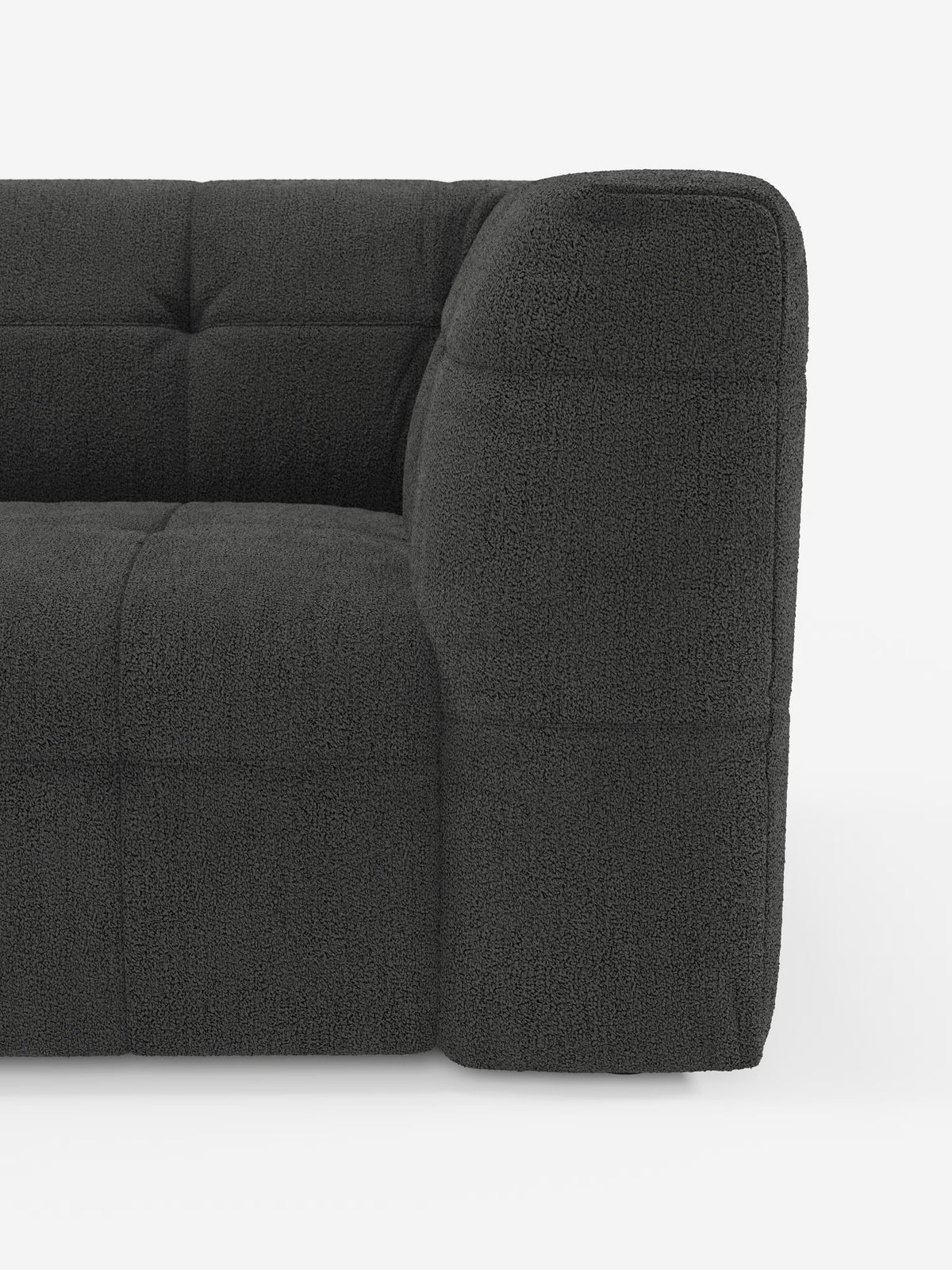 Un primo piano del lato destro del divano modulare Mosaic Divano a 3 e 4 posti in bouclé di Divani.Store, che mette in risalto i braccioli spessi, i cuscini capitonné e il rivestimento in tessuto T21 smacchiabile e dalla trama rigata, su uno sfondo bianco a tinta unita. È visibile solo una parte di questo moderno divano modulare.