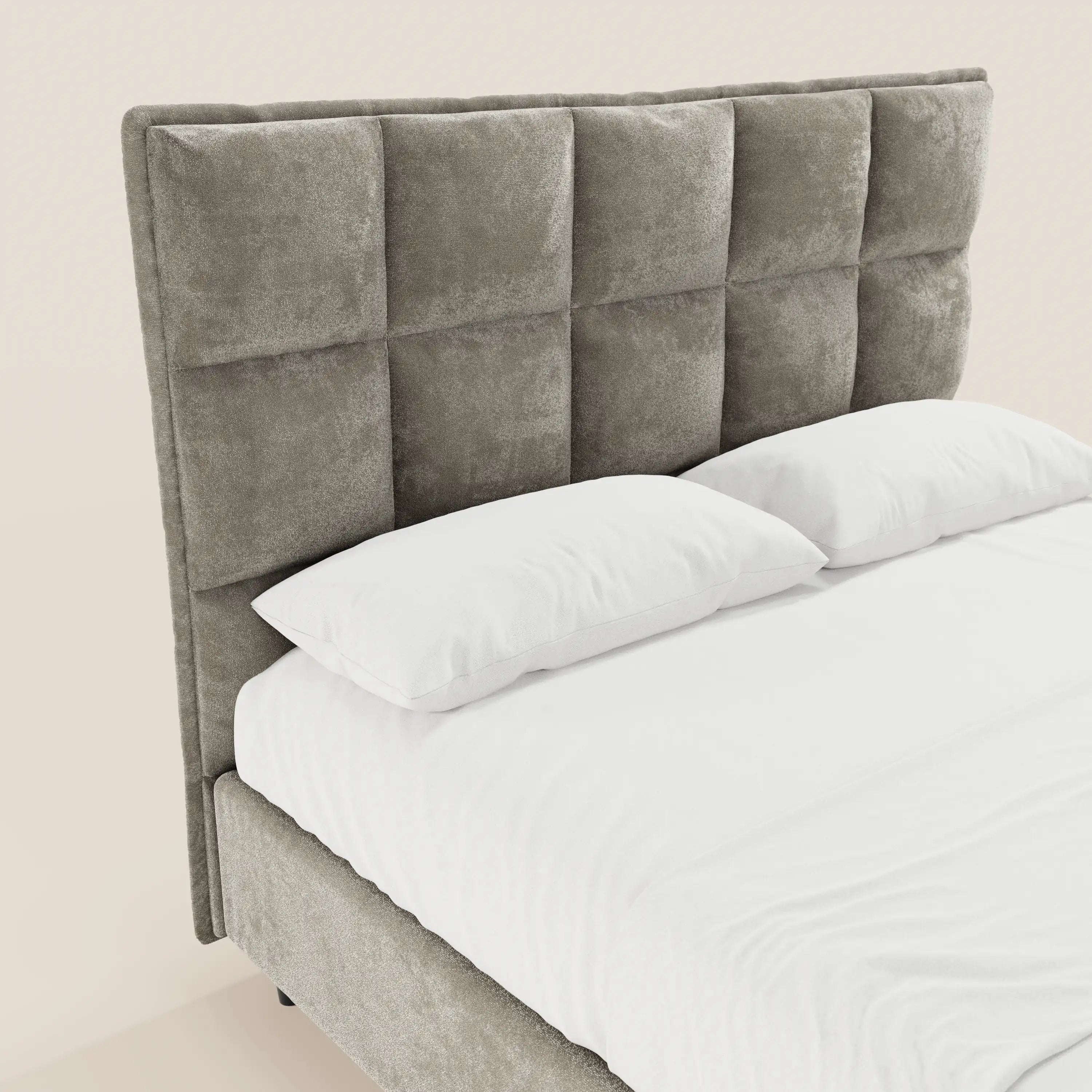 Il letto imbottito AURO di Letti.store presenta una testiera alta e capitonné in ciniglia certificata Oeko-Tex® e una base contenitore, qui raffigurata in grigio con biancheria da letto bianca e due cuscini su uno sfondo chiaro.
