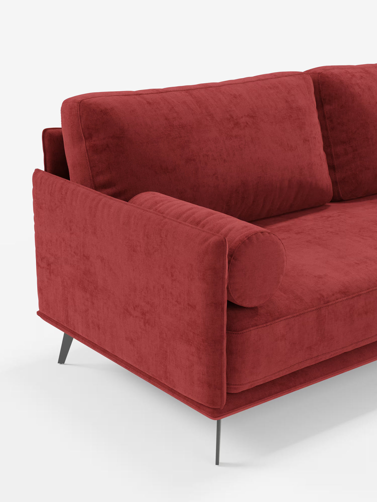 Un primo piano del divano moderno angolare con penisola "Basalto" di Divani.Store, rivestito in rosso, Made in Italy. È caratterizzato da un cuscino cilindrico, morbidi cuscini imbottiti in piuma rivestiti in tessuto T31 antimacchia, braccioli dritti e una base sottile in metallo nero. Lo sfondo è bianco a tinta unita.