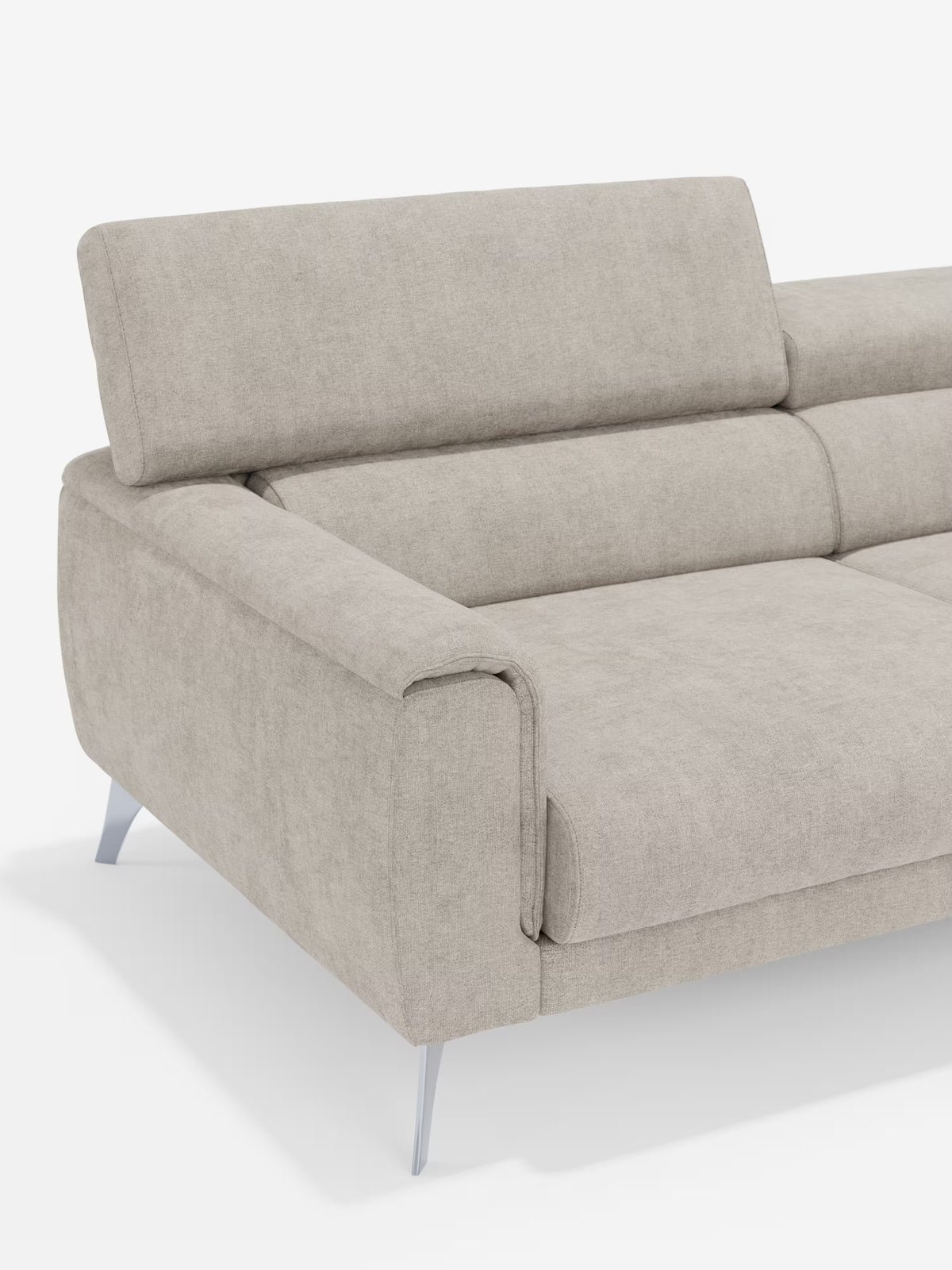 Il divano Caravaggio a 2 e 3 posti di Divani.Store — un moderno divano in tessuto beige chiaro, realizzato nell’elegante tessuto smacchiabile T31 — presenta ampi braccioli, gambe in metallo angolate, cuscini morbidi e un poggiatesta reclinabile. Esaltando il comfort grazie al design con sedute allungabili, di questo elegante divano lineare sono visibili solo il lato sinistro e l’angolo su uno sfondo bianco a tinta unita.