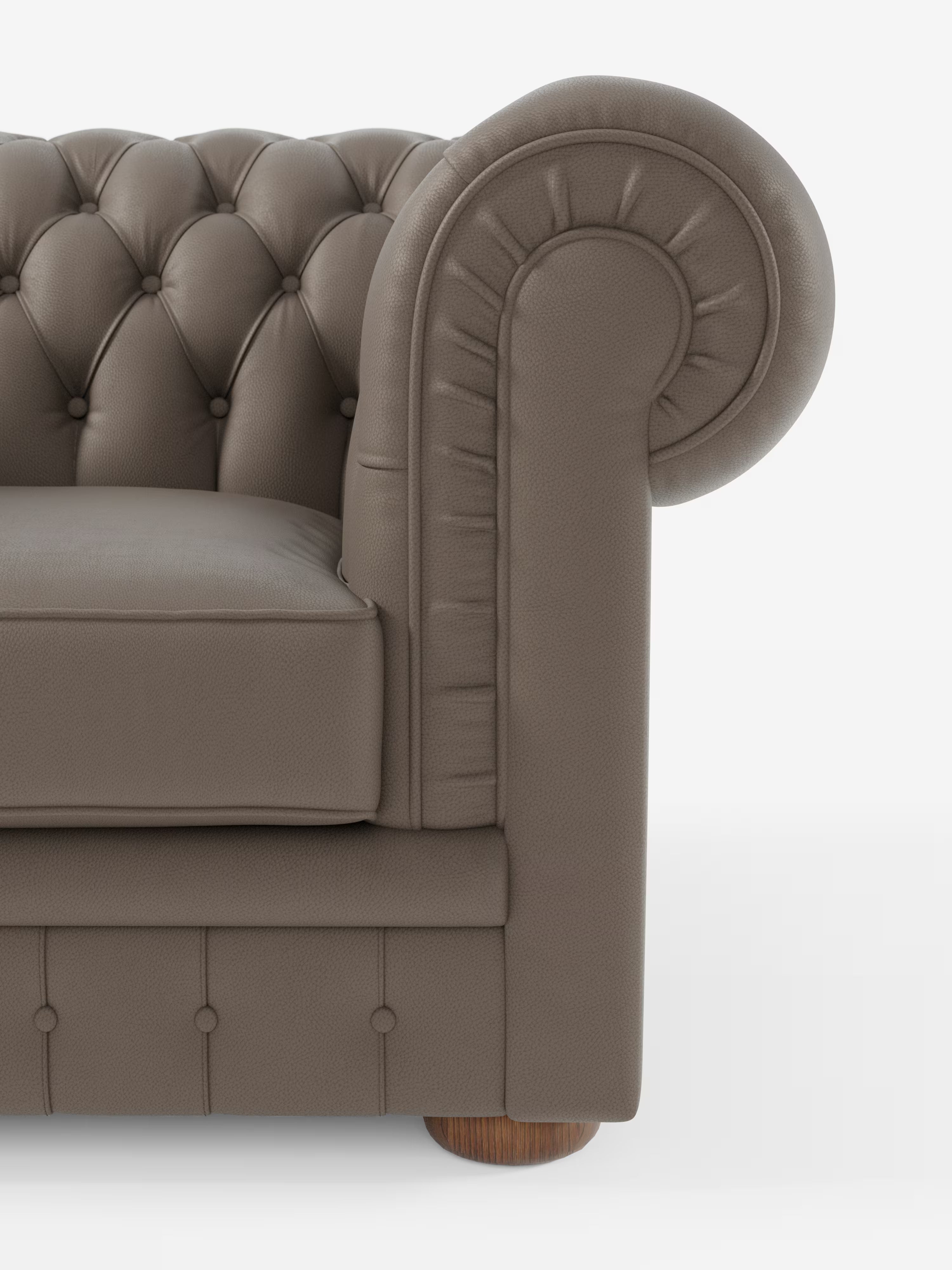 Primo piano del lato destro della poltrona Chester in vera pelle spessorata con capitonné artigianale di Divani.Store, che mette in risalto il rivestimento in vera pelle marrone granulata, la lavorazione artigianale a capitonné, i braccioli arrotondati e la gamba in legno a vista su uno sfondo bianco a tinta unita.