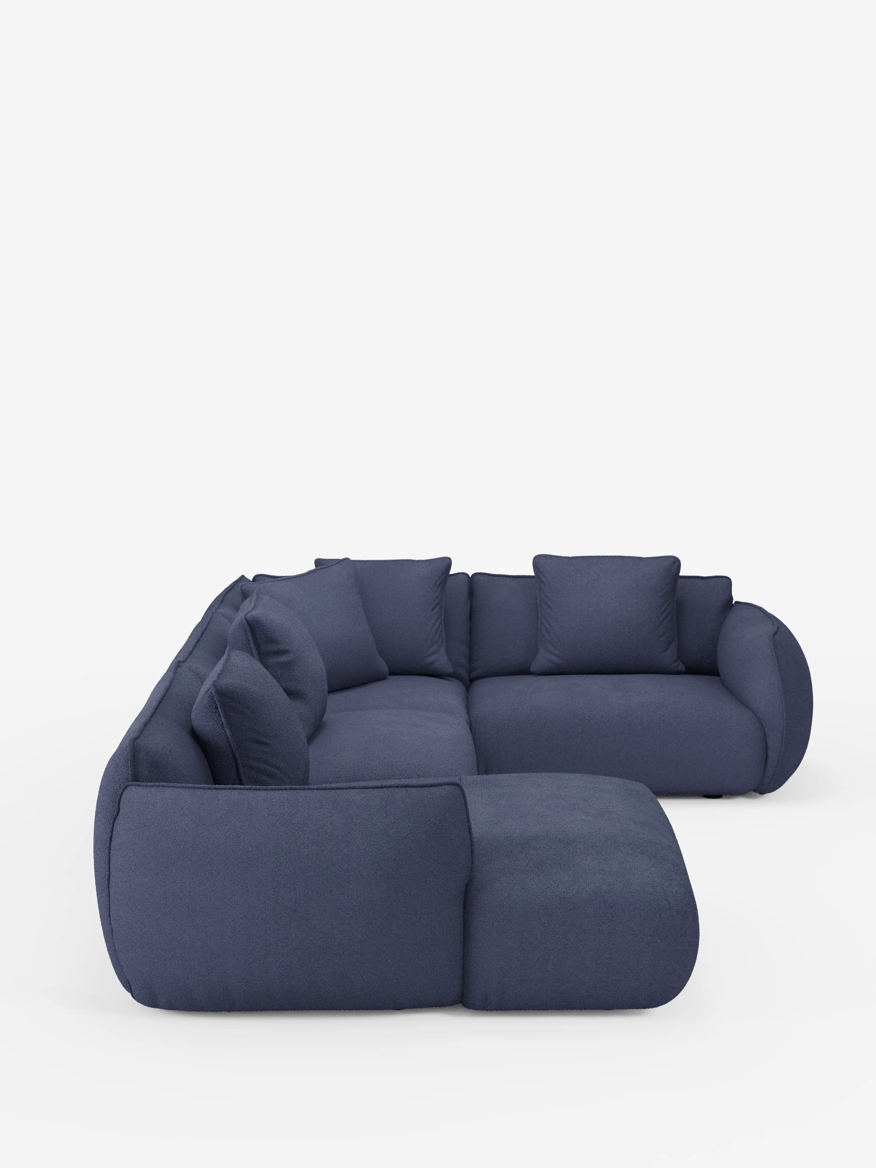 Il divano angolare panoramico componibile Nimbus con penisola e angolo in tessuto smacchiabile t33 di Divani.Store è qui presentato nella versione blu scuro. Questo divano componibile contemporaneo a forma di L presenta bordi arrotondati, un profilo basso e morbidi cuscini, completati da diversi cuscini dello schienale abbinati per un maggiore comfort e stile, il tutto presentato su uno sfondo bianco.