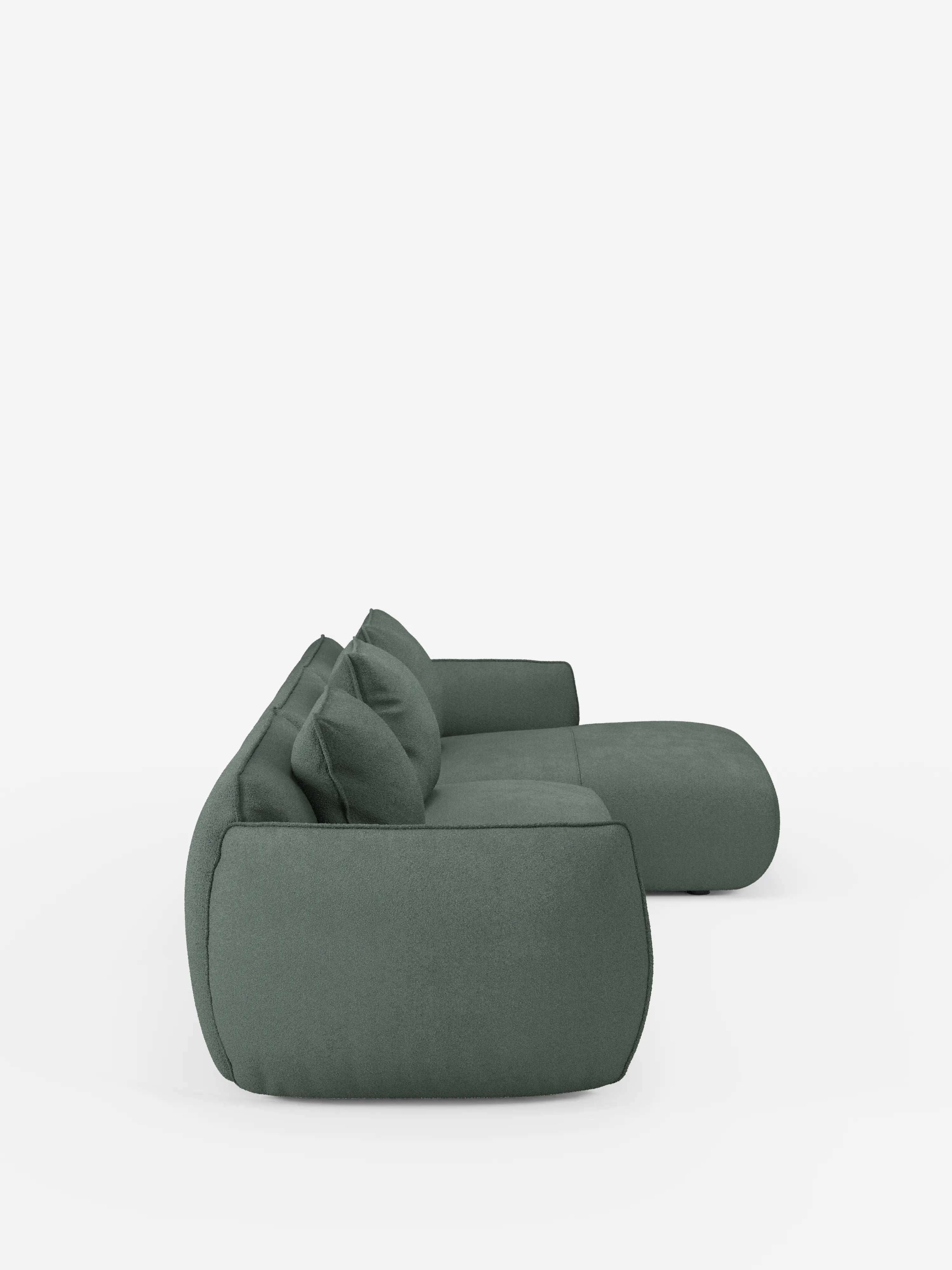 Il divano angolare con penisola componibile Nimbus di Divani.Store è raffigurato di profilo su uno sfondo bianco a tinta unita. Questo moderno divano modulare verde, realizzato in morbido tessuto T33 effetto cotone resistente alle macchie, presenta un profilo basso e lussuoso con cuscini spessi e bordi arrotondati che gli conferiscono un aspetto morbido e accogliente. Il design comprende tre cuscini dello schienale e ampi braccioli.