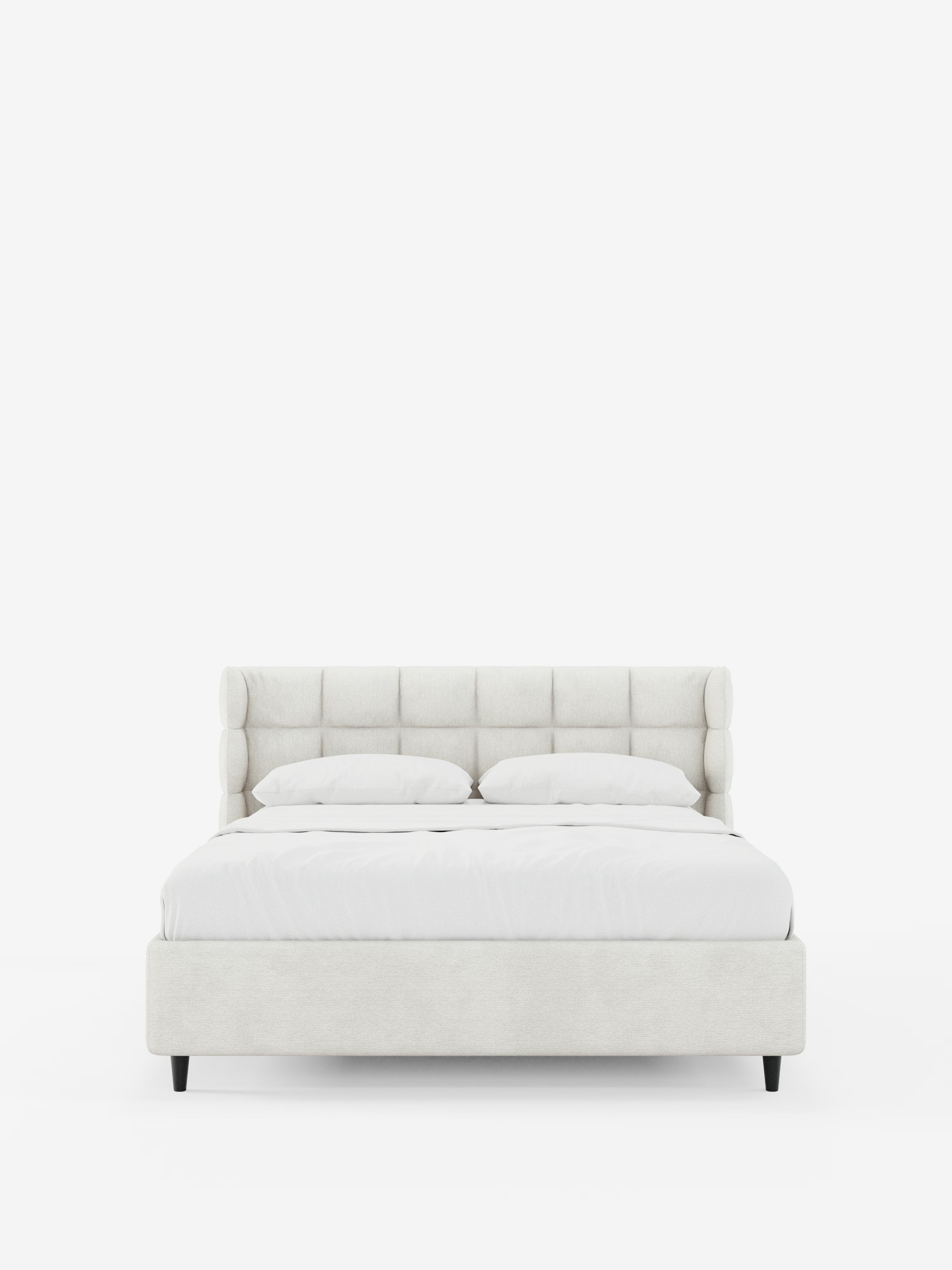 RAGNAR, letto imbottito con contenitore di Letti.store, caratterizzato da un’elegante testiera capitonné avvolgente in tessuto certificato Oeko-Tex® color beige chiaro. Il design minimalista comprende lenzuola bianche, due cuscini e gambe nere corte, su uno sfondo bianco neutro.
