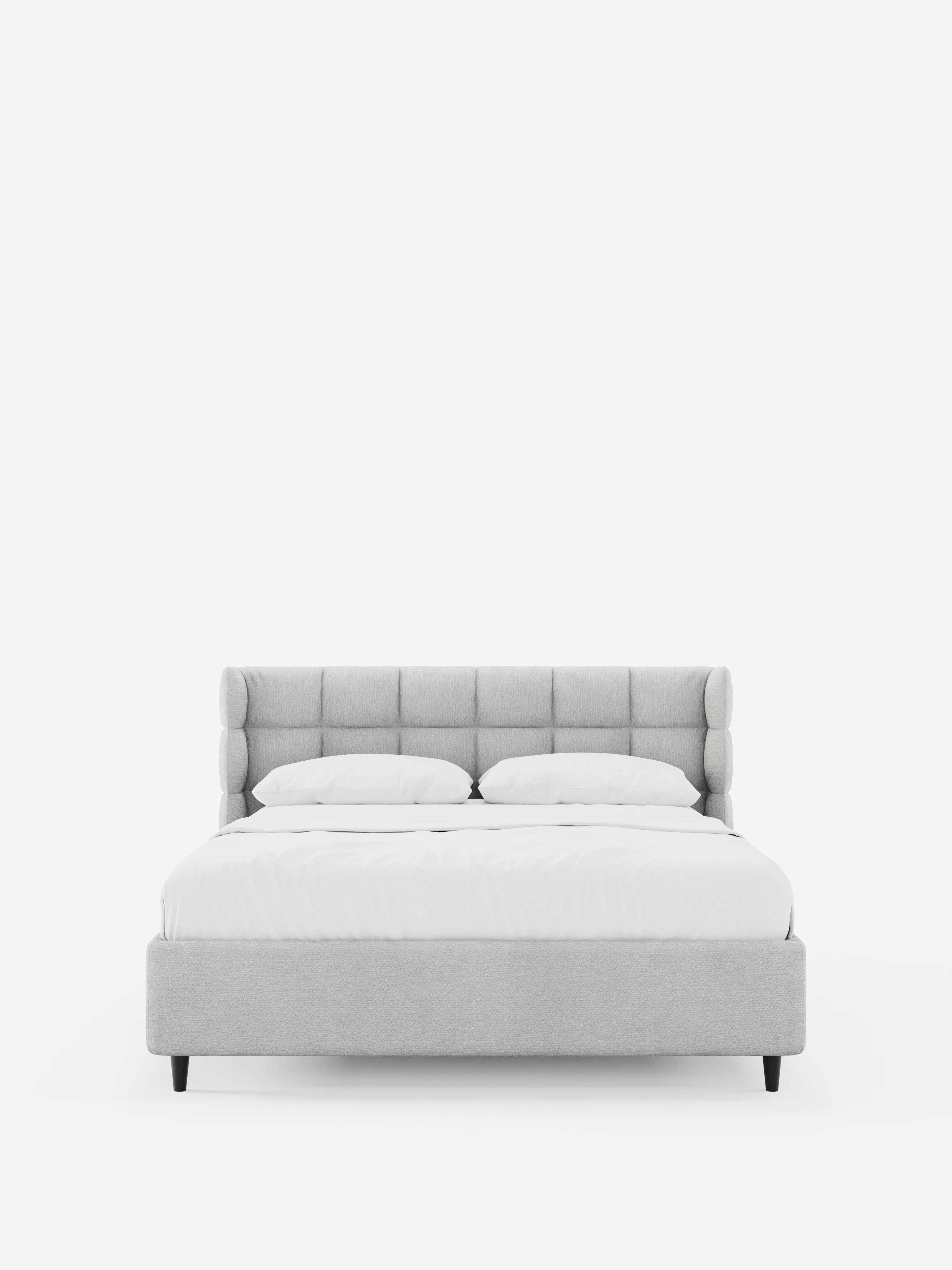 Un letto imbottito RAGNAR in stile contemporaneo con contenitore e testiera capitonné avvolgente di Letti.store, rivestito in tessuto grigio chiaro certificato Oeko-Tex®, presenta una testiera imbottita e avvolgente ed è abbinato a biancheria da letto bianca e due cuscini. Il letto poggia su corte gambe nere, posizionato al centro di uno sfondo bianco a tinta unita.