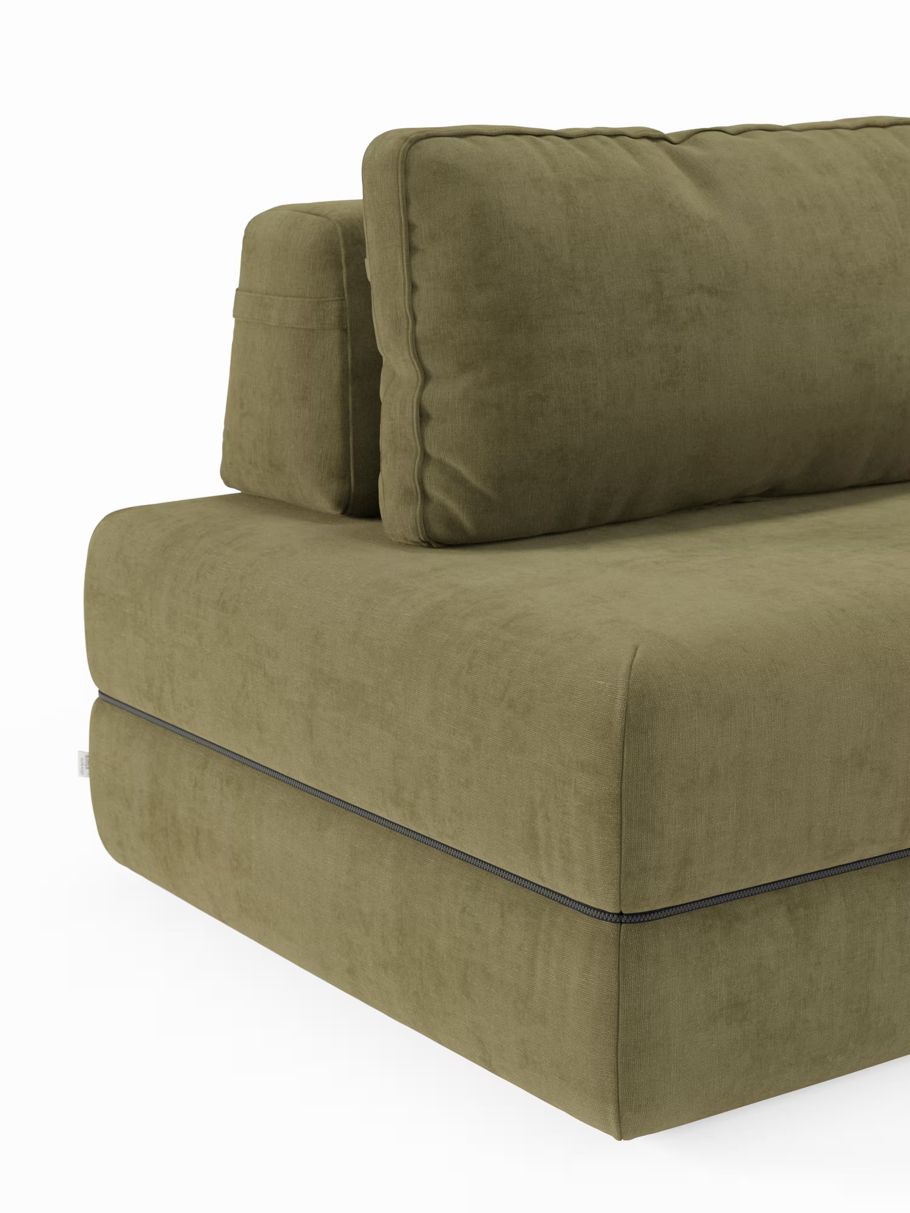 Un primo piano dell'angolo di un divano letto matrimoniale Rift di Divani.Store, qui raffigurato in verde oliva. Il divano componibile è caratterizzato da cuscini imbottiti e da un rivestimento in tessuto morbido, con la cucitura lungo il bordo inferiore che risalta su uno sfondo bianco a tinta unita.