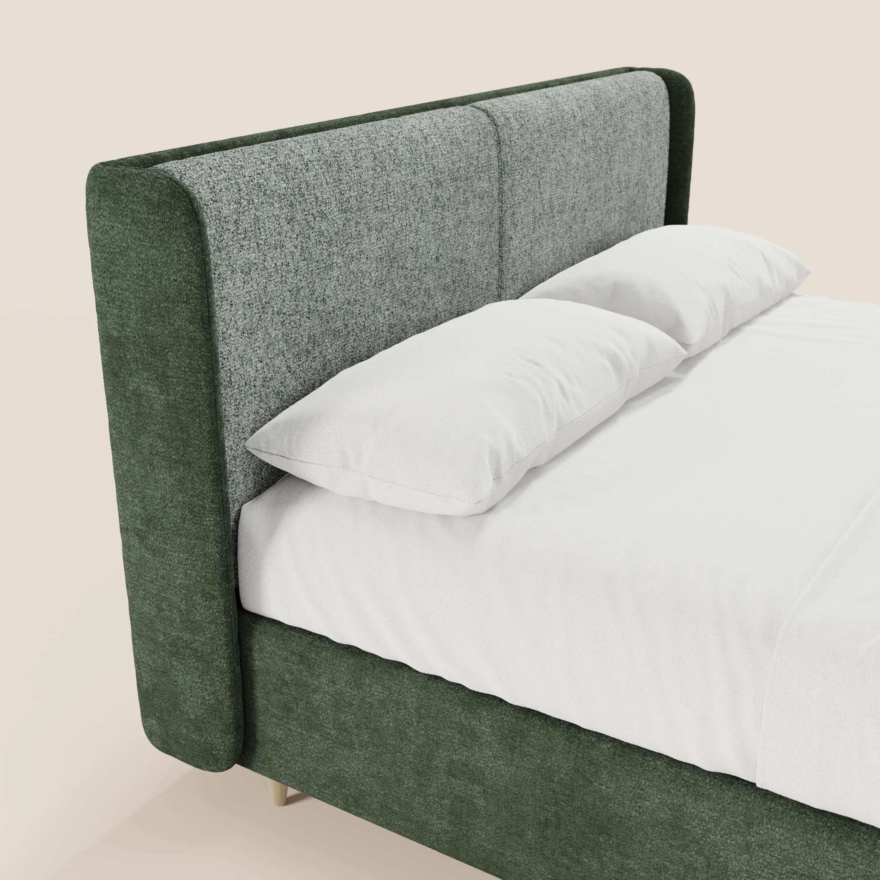 Un primo piano del letto imbottito bicolore VALKIRIA di Letti.store, caratterizzato da una testiera curva e avvolgente con i lati verde scuro e la parte frontale grigia testurizzata, biancheria da letto e cuscini bianchi, oltre a una struttura imbottita abbinata di colore verde scuro.