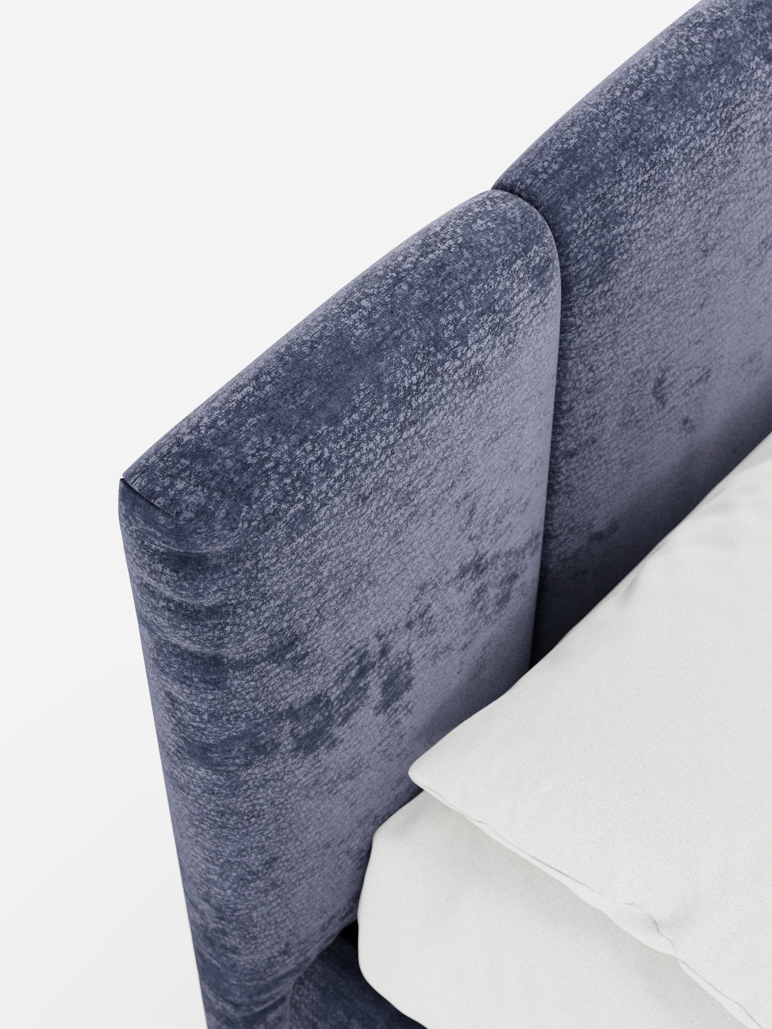 Un primo piano dall'alto del letto imbottito ARKAM con contenitore e testiera a lavorazione verticale di Letti.store, caratterizzato da una testiera blu scuro testurizzata con cuciture verticali, realizzata in tessuto certificato Oeko-Tex®. Il letto è abbinato a biancheria da letto di un bianco brillante, cuscini e lenzuola con i bordi a vista, il tutto su uno sfondo bianco a tinta unita per mettere in risalto il suo design shabby chic e la funzionale base contenitore.