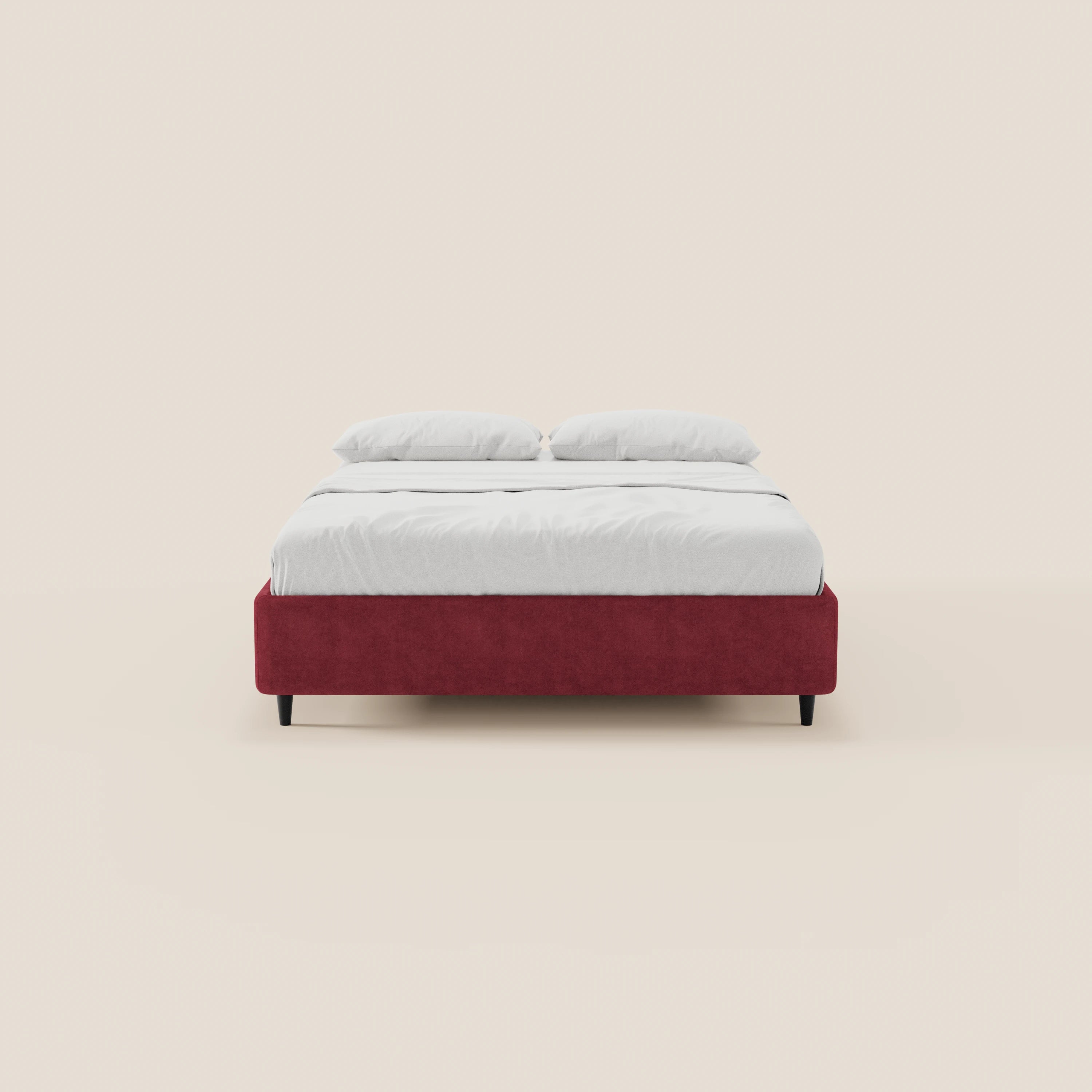 Il letto sommier imbottito ERON di Letti.store presenta una struttura in tessuto rosso impermeabile certificato Oeko-Tex, lenzuola bianche e due cuscini bianchi. È dotato di gambe corte nere, un design moderno dal profilo basso e un pratico vano portaoggetti.