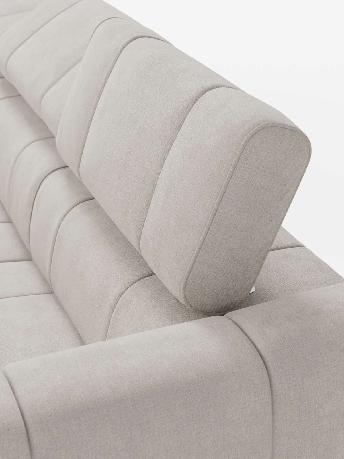 Un divano modulare Giotto beige a 4 posti con poggiatesta reclinabili e funzione relax elettrica opzionale, rivestito in tessuto smacchiabile T23 con trapuntatura a canali verticali; uno dei poggiatesta imbottiti è inclinato verso l’alto, lasciando intravedere un’elegante cerniera in metallo.