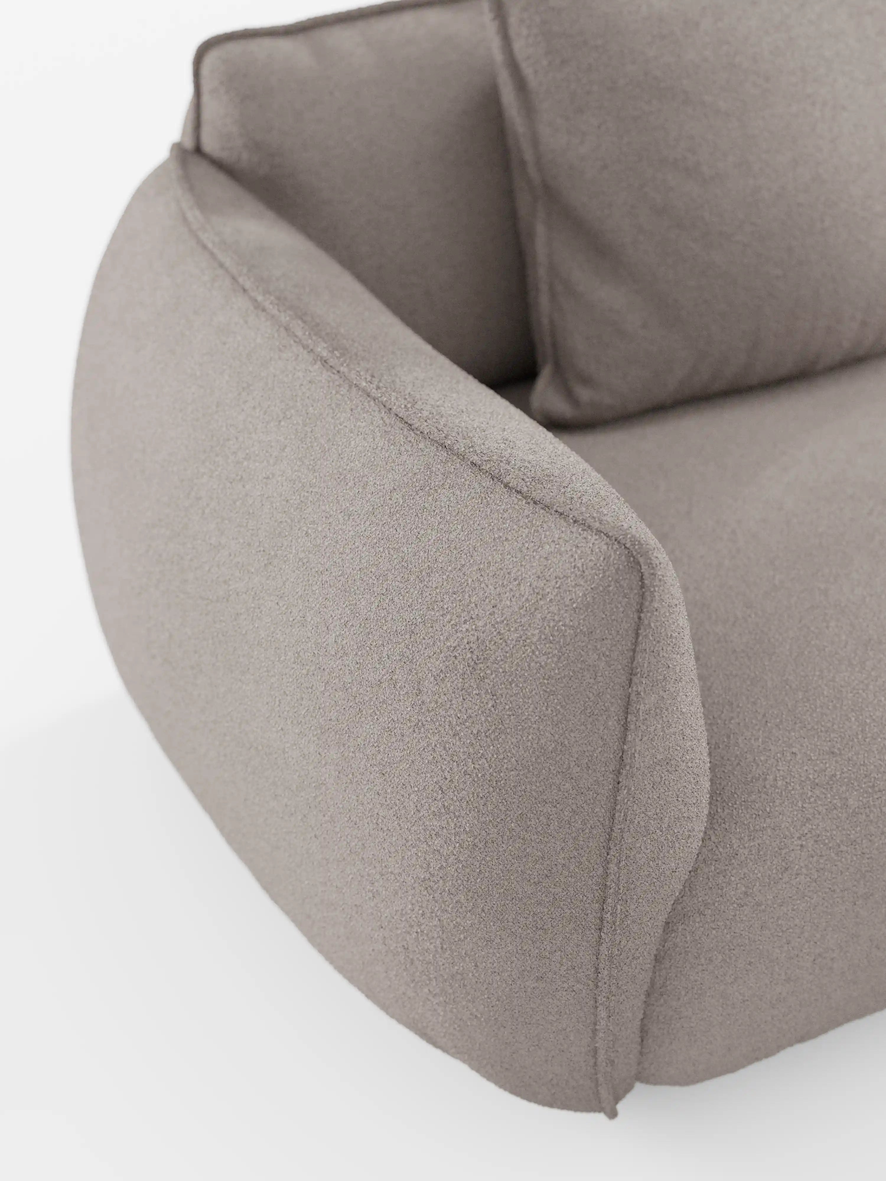 Primo piano del divano angolare con penisola componibile Nimbus di Divani.Store, rivestito in tessuto grigio chiaro, morbido, effetto cotone e resistente alle macchie (T33). Il design moderno è caratterizzato da linee morbide e arrotondate, con braccioli e schienale delicatamente ricurvi, che richiamano i contorni eleganti tipici dei divani moderni o modulari. Il tutto su uno sfondo bianco a tinta unita.