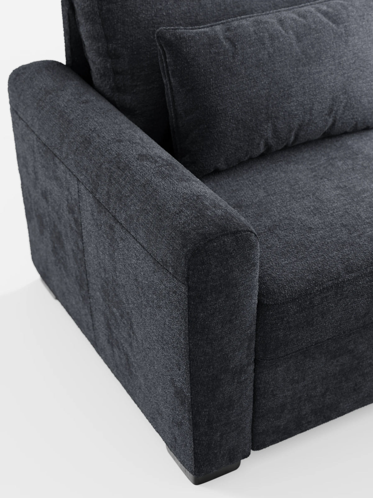 Un primo piano del divano letto Ottaviano color grigio antracite con letto estraibile – penisola reversibile e contenitore in tessuto materico smacchiabile, con particolare attenzione al bracciolo testurizzato e al cuscino dello schienale rettangolare su uno sfondo bianco a tinta unita.