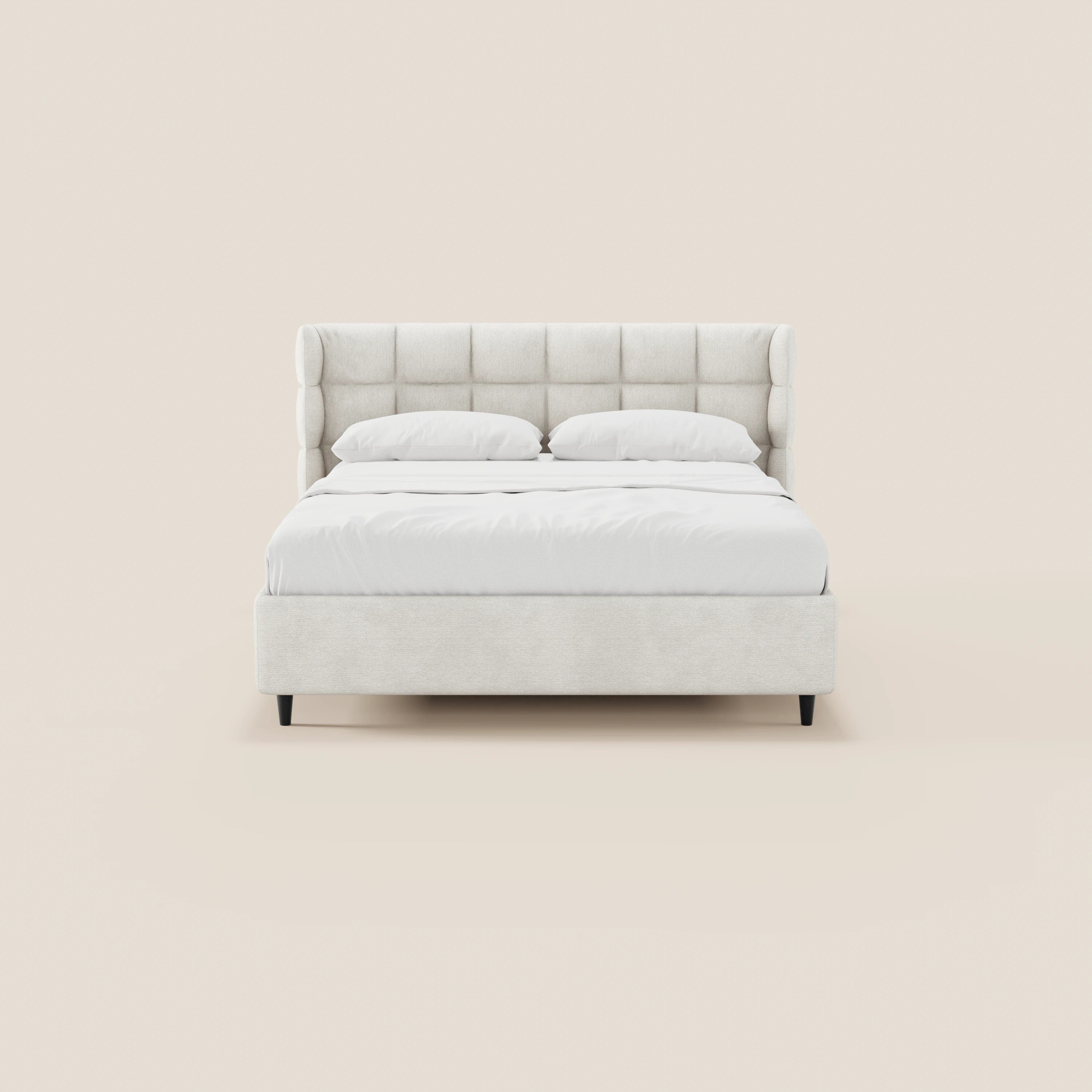 Il letto imbottito RAGNAR di Letti.store presenta un'alta testiera capitonné avvolgente in tessuto beige certificato Oeko-Tex®, biancheria da letto bianca e due cuscini. Questo letto minimalista poggia su quattro gambe corte nere e si distingue su uno sfondo beige a tinta unita.
