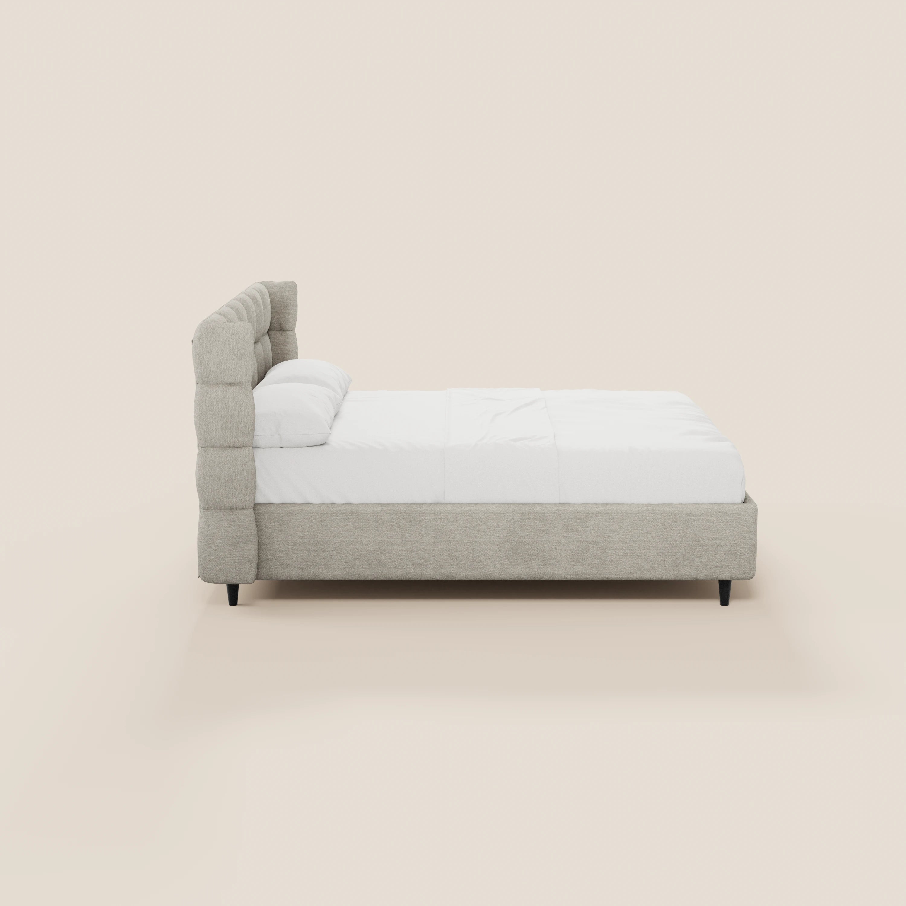 Il letto imbottito RAGNAR di Letti.store è caratterizzato da un tessuto beige certificato Oeko-Tex®, una testiera avvolgente con lavorazione capitonné, biancheria da letto bianca, gambe nere e una moderna struttura imbottita con vano contenitore, raffigurato in una vista laterale su uno sfondo chiaro.