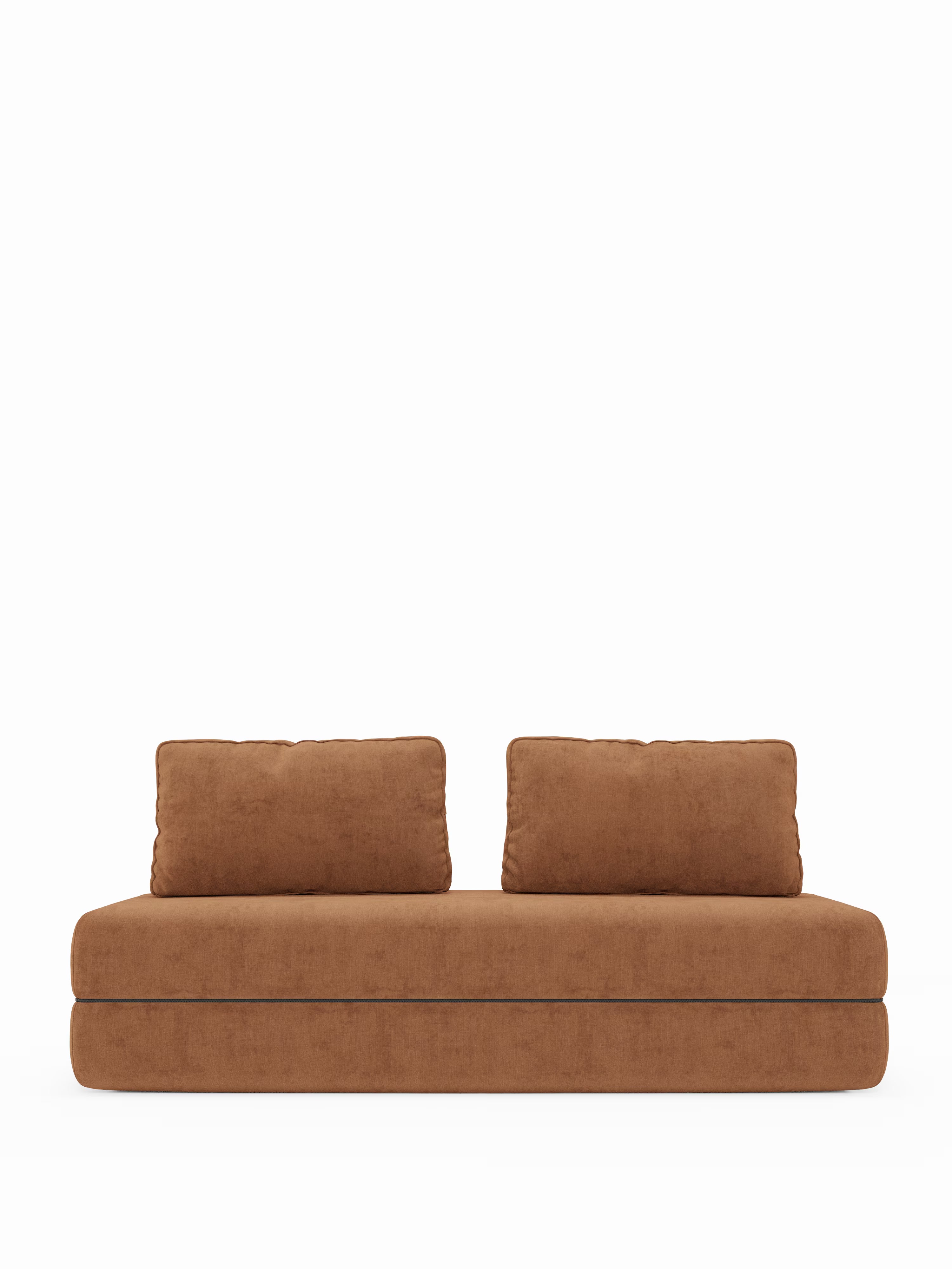 Un divano marrone moderno e minimalista — il divano letto matrimoniale a 2 e 3 posti con schienali mobili “Rift” di Divani.Store — è caratterizzato da due cuscini rettangolari coordinati e fa da contrappunto a uno sfondo bianco a tinta unita. Questo divano letto presenta un design dal profilo ribassato con bordi morbidi e arrotondati, senza gambe o braccioli a vista, offrendo il comfort raffinato dello stile contemporaneo grazie a un materasso in memory foam T31 alto 22 cm.