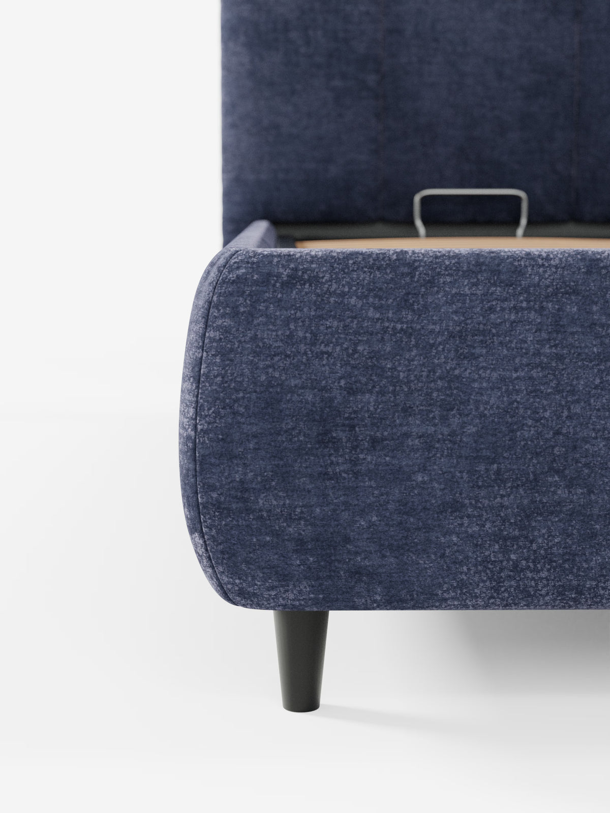 Primo piano del letto imbottito ARKAM con contenitore e testiera a lavorazione verticale di Letti.store, caratterizzato da un rivestimento in tessuto blu navy certificato Oeko-Tex®, una gamba affusolata nera e un cassetto parzialmente aperto con maniglia in metallo — il tutto su uno sfondo bianco a tinta unita per esaltarne lo stile shabby chic.