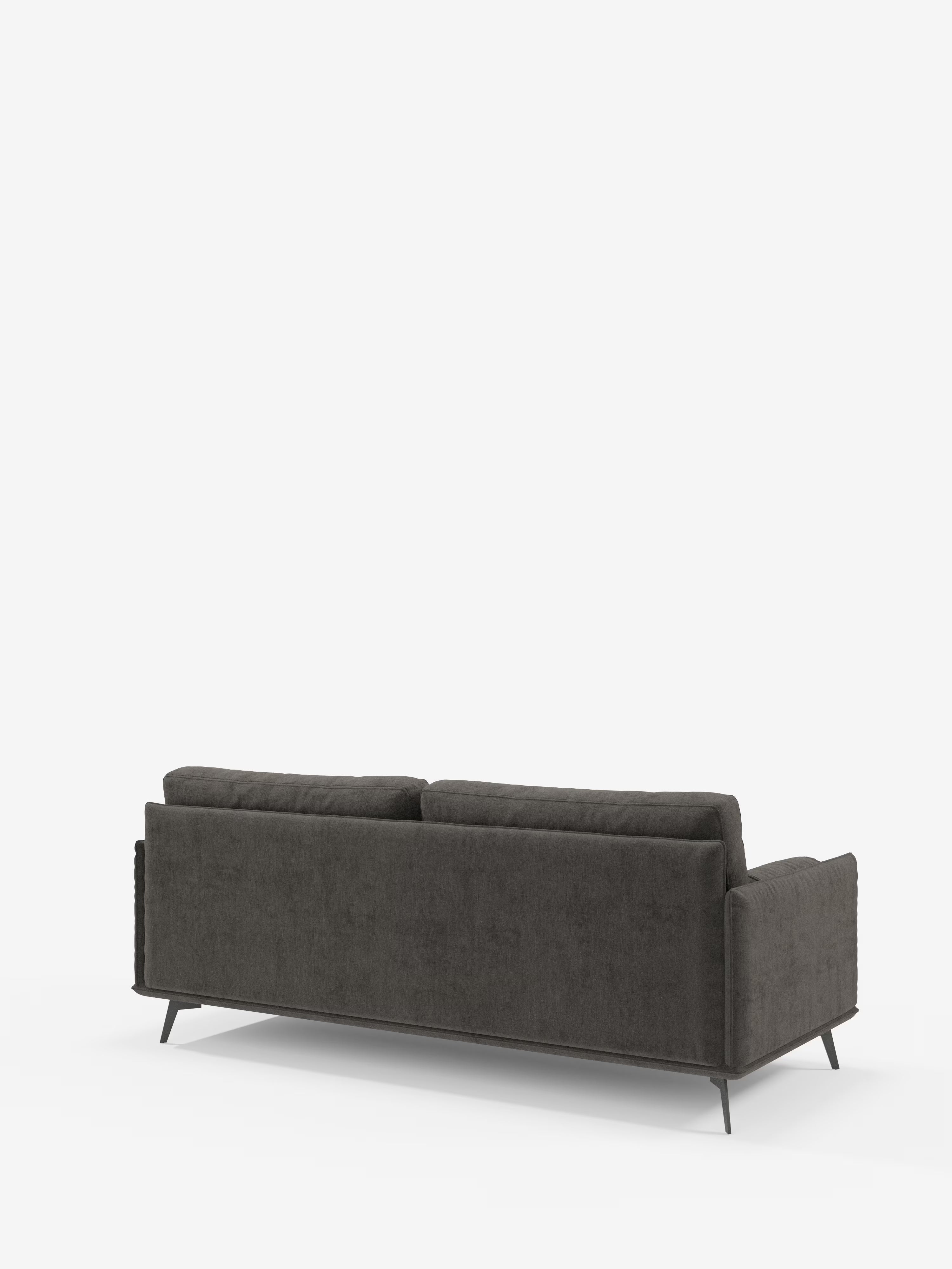 Basalto, divano lineare a 2 o 3 posti con seduta unica e base in metallo T31 di Divani.Store, elegante divano grigio scuro dal design moderno, con schienale morbido e gambe in metallo leggermente angolate, visto da dietro su sfondo bianco. Realizzato in tessuto antimacchia per una facile manutenzione, presenta linee pulite e un look contemporaneo che si adatta perfettamente agli interni minimalisti.