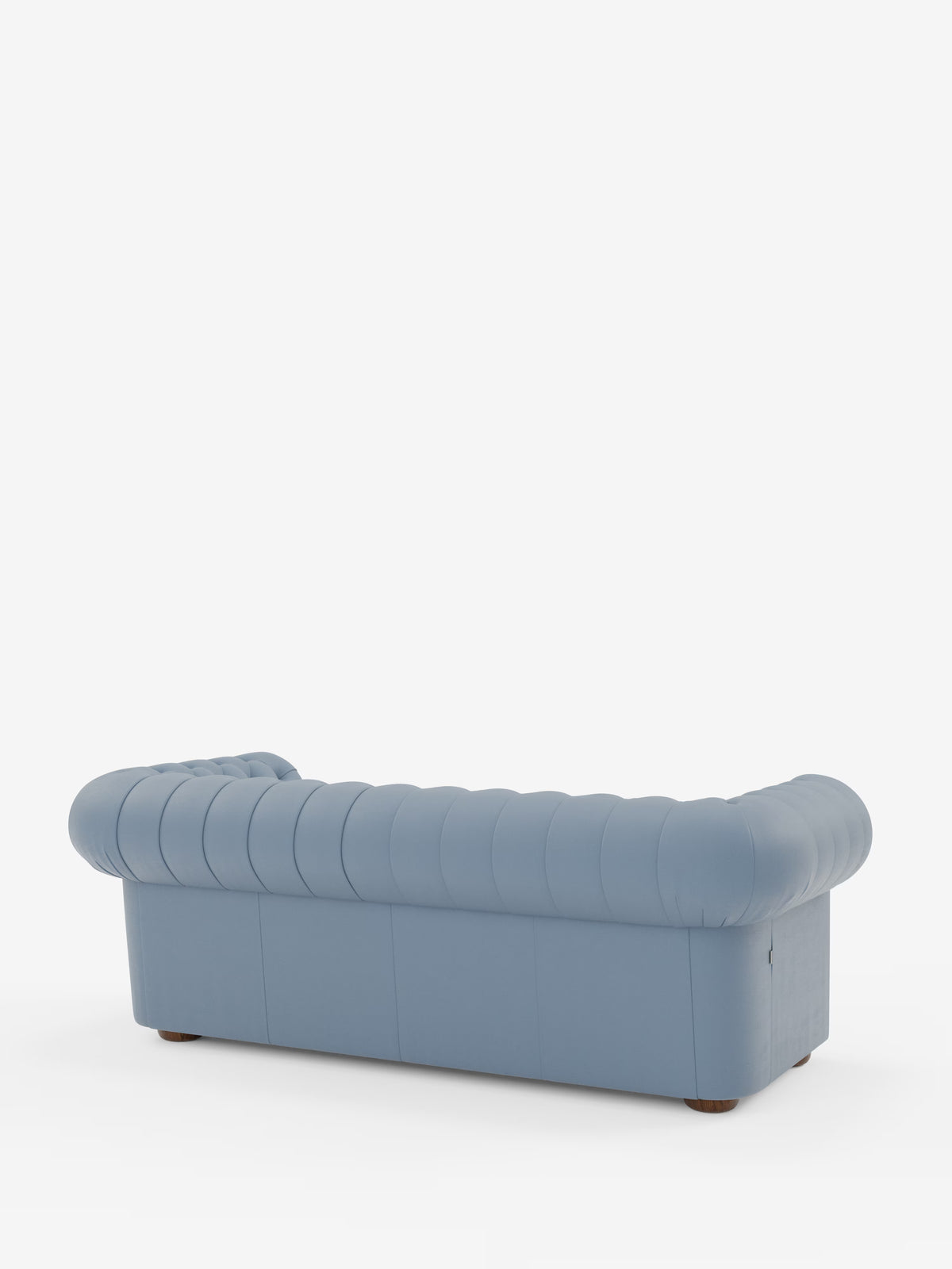Un divano Chesterfield azzurro, imbottito – Divano Chesterfield in vera pelle spessorata a 2 e 3 posti di Divani.Store – è ripreso di profilo, visto da dietro. Questo elegante divano artigianale italiano presenta braccioli profondi e arrotondati e uno schienale con dettagli trapuntati verticali. Lo sfondo è bianco a tinta unita.