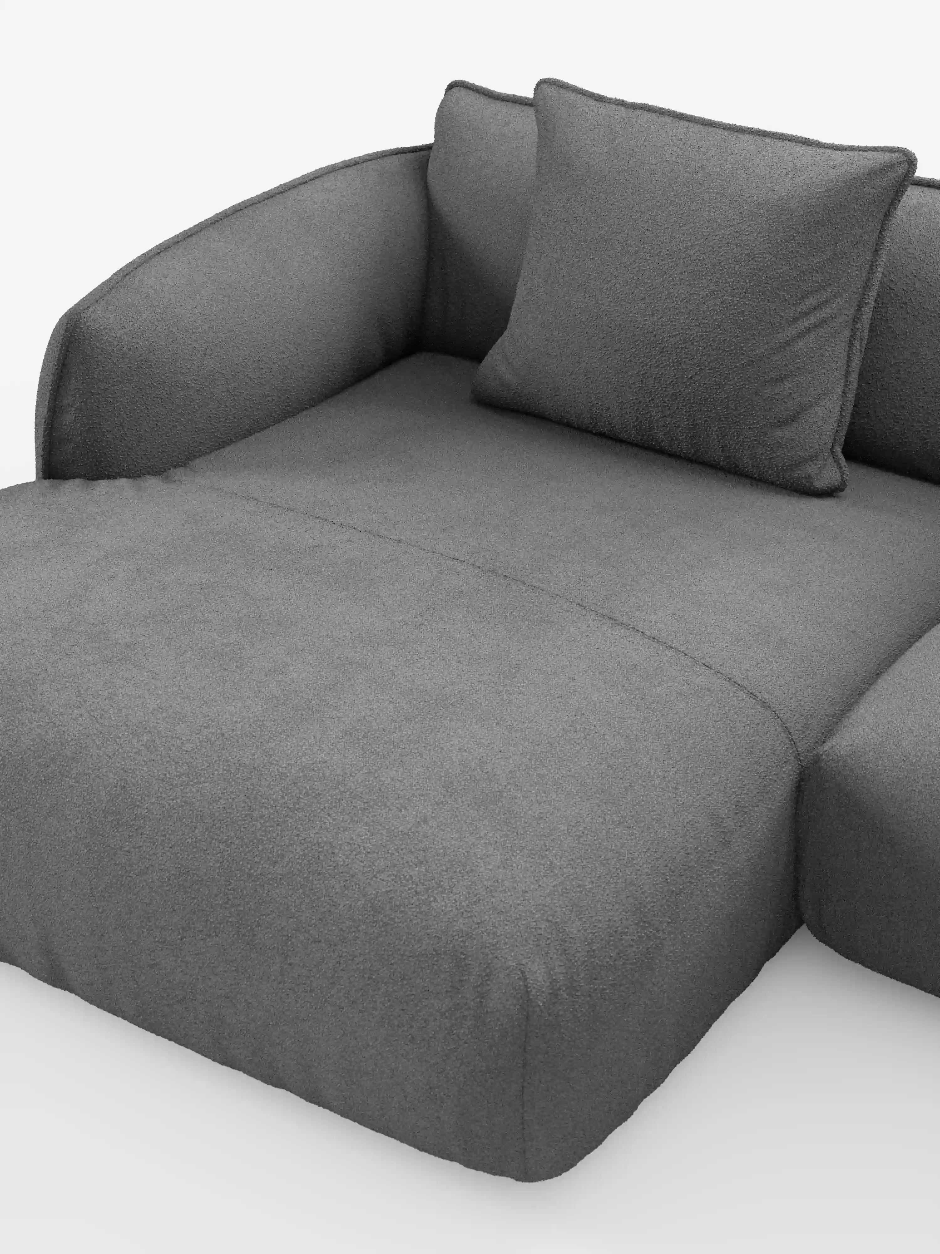 Un divano componibile spazioso e dal design contemporaneo in tessuto grigio — il divano angolare panoramico componibile con penisola e angolo in tessuto smacchiabile T33 “Nimbus” di Divani.Store — presenta braccioli dalle linee elegantemente curve e un cuscino dello schienale in tinta, il tutto su uno sfondo bianco a tinta unita. Il suo rivestimento testurizzato e facile da pulire appare morbido e invitante, creando un’area salotto accogliente e rilassante.