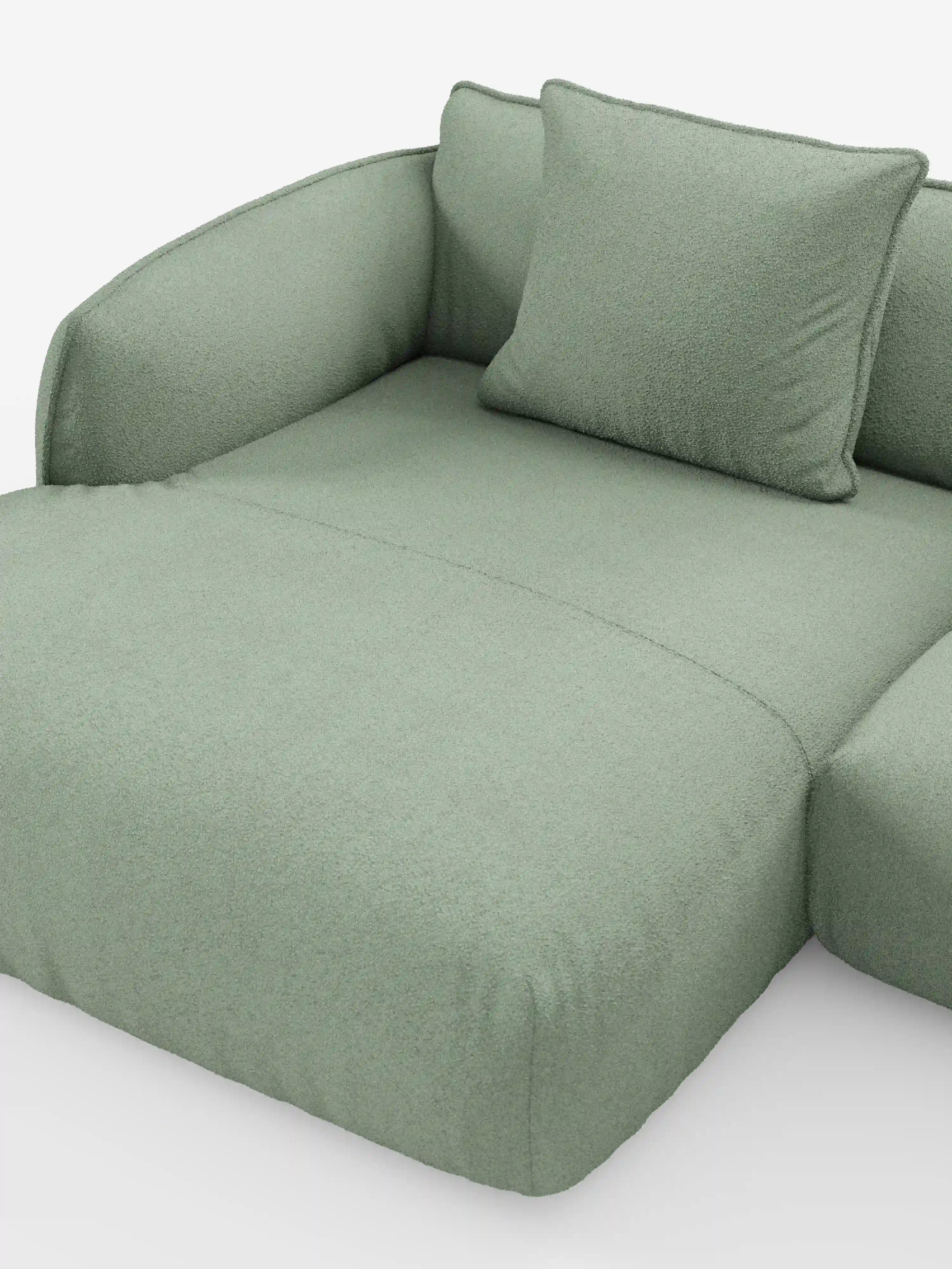 Un primo piano del divano angolare panoramico componibile Nimbus con penisola e angolo in tessuto smacchiabile T33 di Divani.Store, caratterizzato da un design moderno in verde chiaro con braccioli elegantemente ricurvi e un cuscino coordinato. Il rivestimento morbido e dalla trama particolare evoca l'eccellenza artigianale del Made in Italy, mentre lo sfondo bianco a tinta unita accentua l'estetica minimalista e confortevole di questo elemento d'arredo componibile.