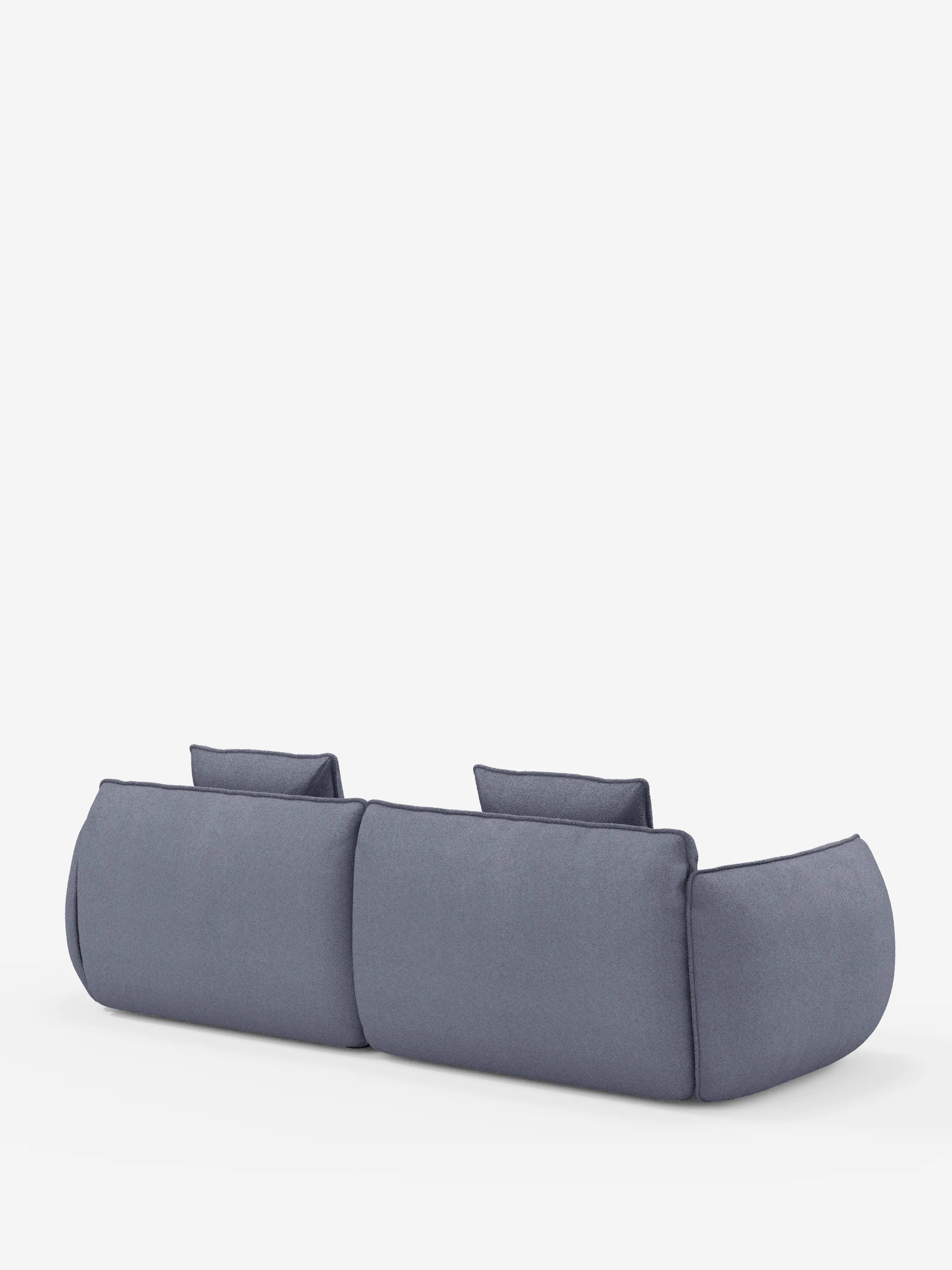 Il divano Nimbus, un modello moderno, minimalista e dal profilo basso, a 3 posti, modulare e componibile da 250 cm di Divani.Store, in grigio, caratterizzato da bordi arrotondati e due poggiatesta, è ripreso di retro su uno sfondo bianco a tinta unita. Il divano presenta un tessuto morbido, effetto cotone, sfoderabile e antimacchia (tessuto smacchiabile effetto cotone t33) e un design semplice e contemporaneo.