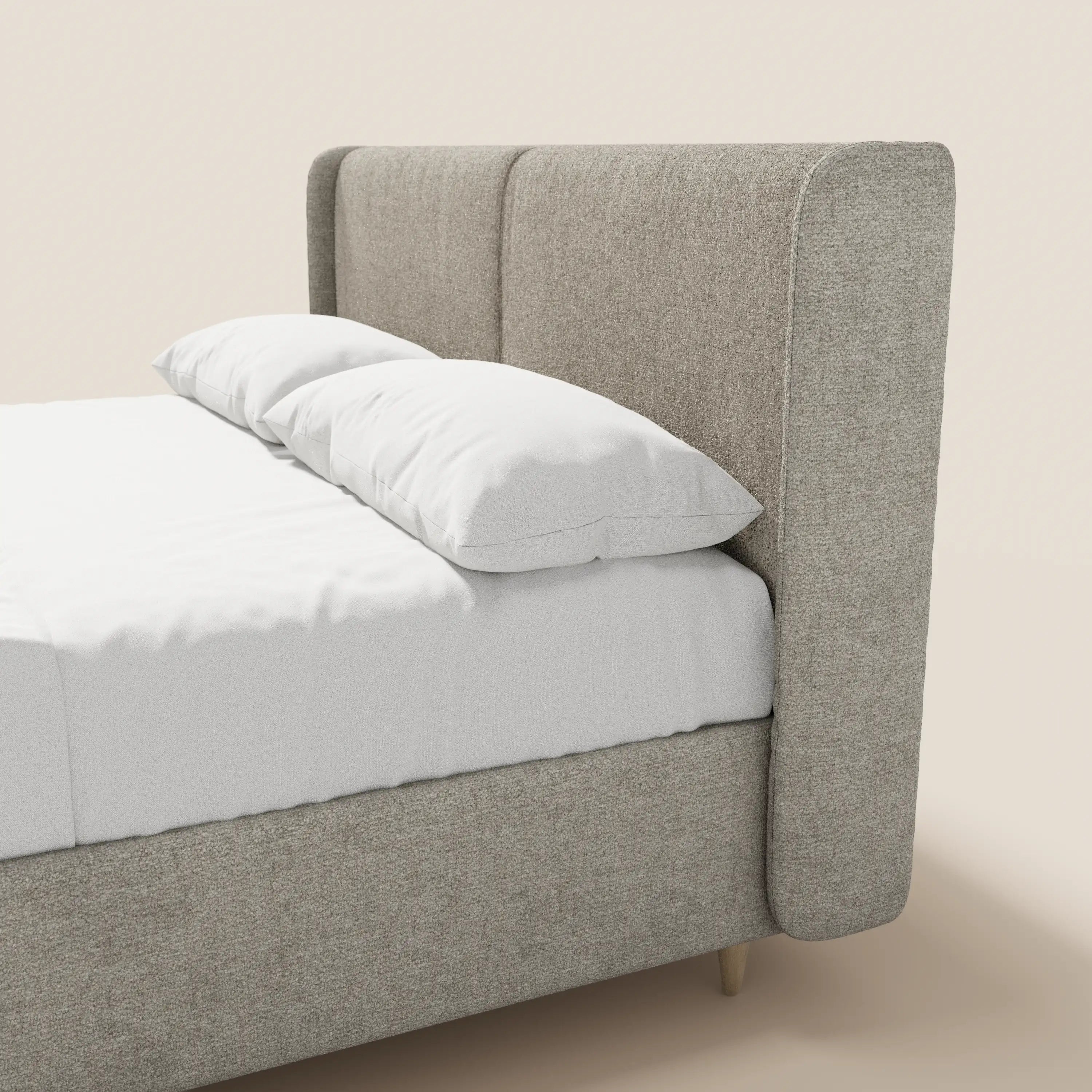 Un primo piano del letto imbottito bicolore VALKIRIA di Letti.store, caratterizzato da una testiera ricurva e avvolgente e da cuscini dello schienale. Il letto è disposto con cura in un ambiente luminoso, mettendo in risalto il suo elegante design italiano e il vano contenitore integrato.