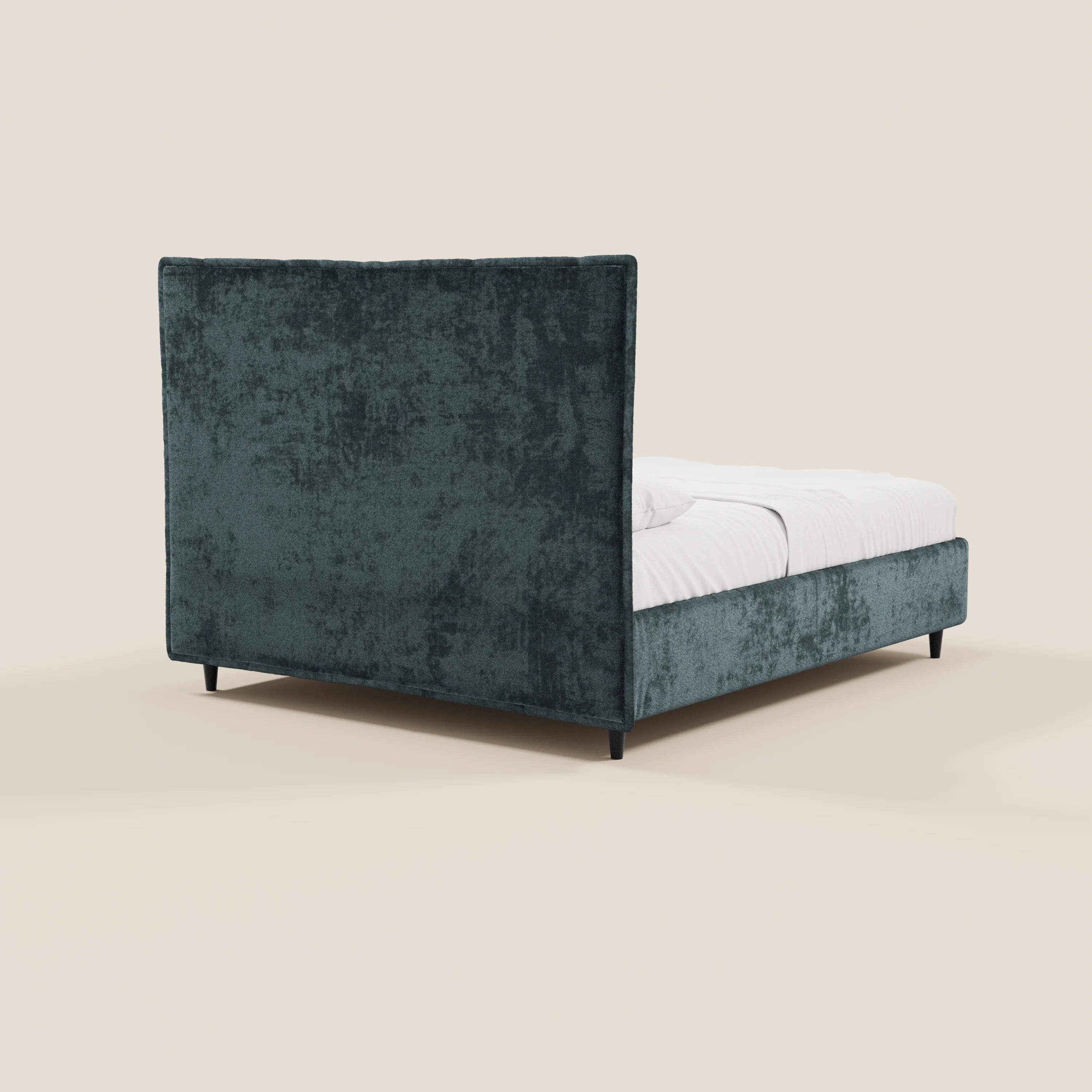 Il letto imbottito AURO con contenitore di Letti.store presenta una testiera alta e ruvida al tatto di colore blu scuro, realizzata in ciniglia certificata Oeko-Tex®, e una struttura coordinata, rivestita con biancheria da letto bianca e poggiata su gambe nere su uno sfondo beige chiaro.