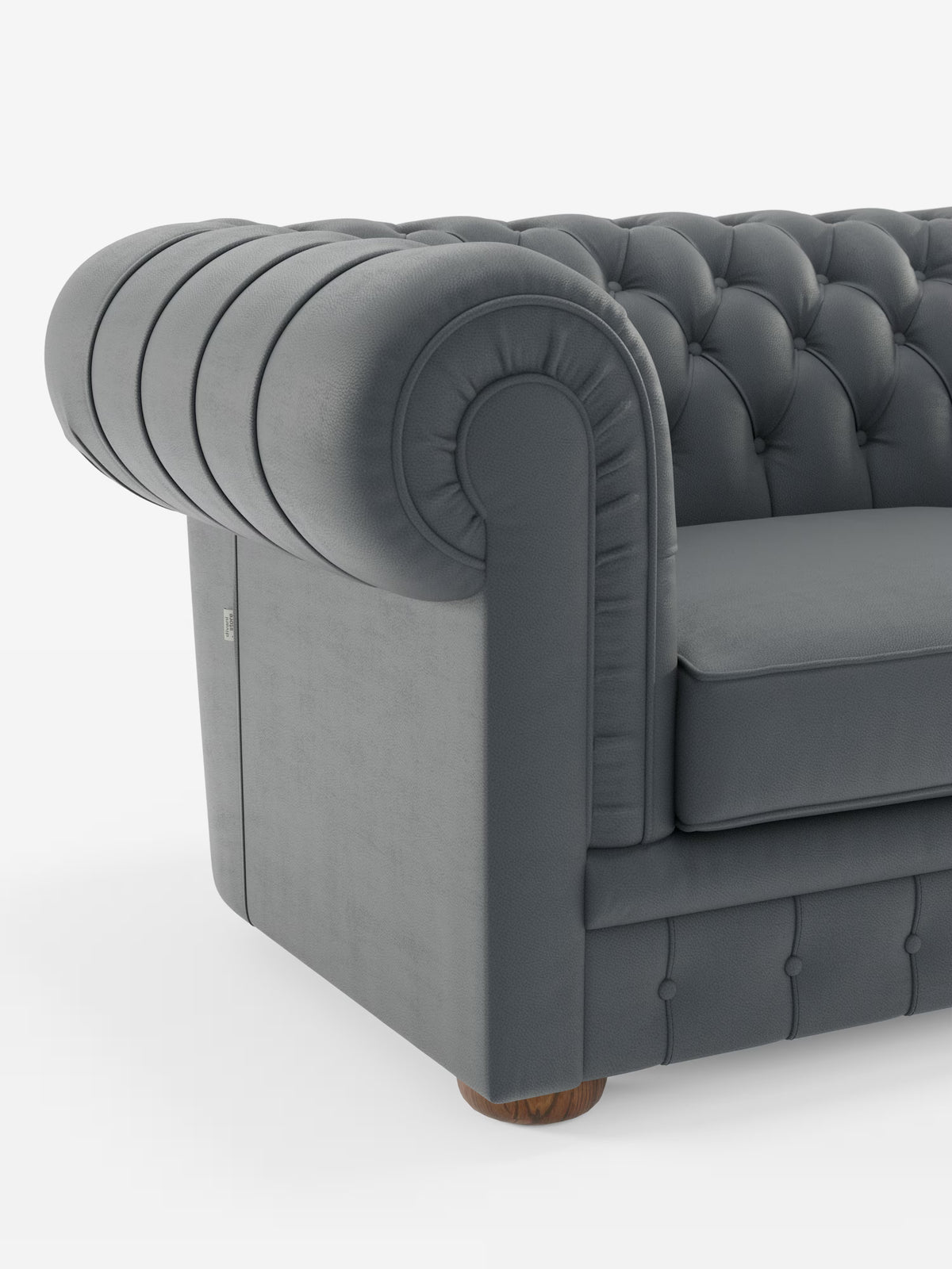 Vista parziale del Chester – Divano Chesterfield in vera pelle spessorata a 2 e 3 posti di Divani.Store, caratterizzato da schienale e braccioli con profonda trapuntatura a bottoni, classici braccioli arrotondati, cuscino di seduta liscio e piccoli piedini in legno. Il lussuoso rivestimento del divano è realizzato in vera pelle spessorata. Questo elegante modello incarna il fascino intramontabile di un divano artigianale di produzione italiana. Lo sfondo è bianco a tinta unita.