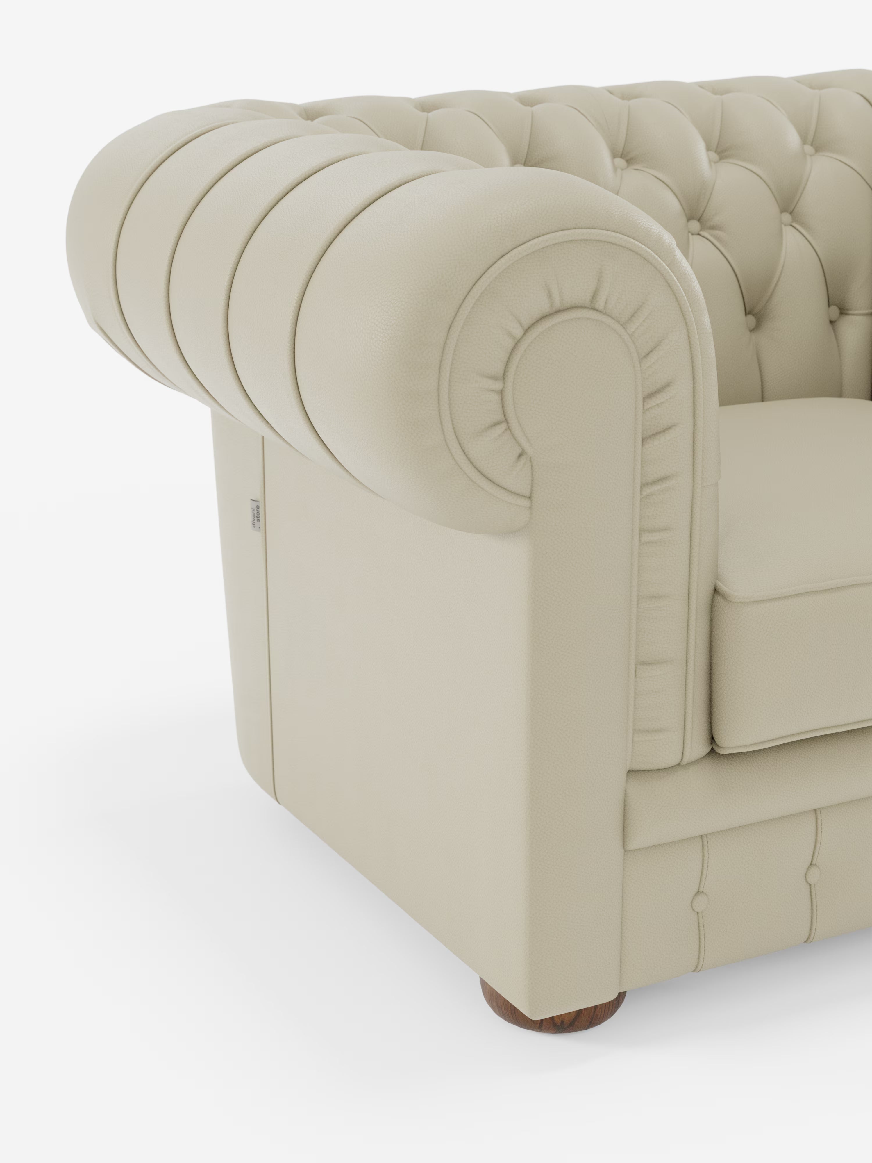 Primo piano della poltrona Chester in vera pelle spessorata con capitonné artigianale di Divani.Store. Questa poltrona in pelle color avorio presenta i classici braccioli arrotondati, una profonda trapuntatura a bottoni e un cuscino morbido e dalla trama ricca. Il rivestimento liscio ne esalta l’aspetto elegante, mentre alla base sono visibili i piedini a pallina in legno. Lo sfondo è bianco a tinta unita.