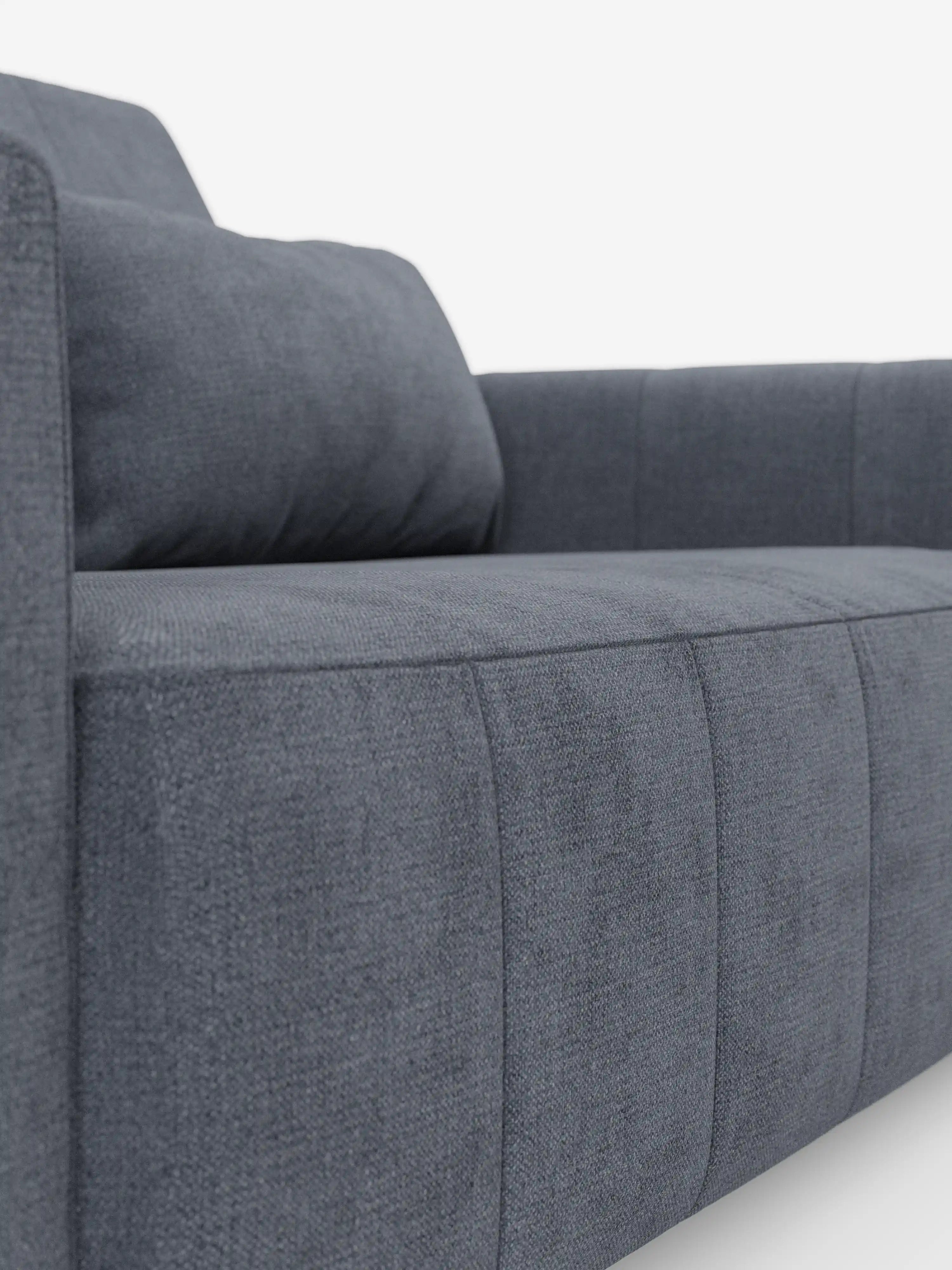 Primo piano del divano dorico a 3 posti con sedute allungabili tramite meccanismo relax elettrico di Divani.Store, caratterizzato da un moderno rivestimento in tessuto grigio scuro smacchiabile T23 con trama leggermente ruvida. Il divano presenta braccioli squadrati e cuciture a vista, che risaltano sullo sfondo bianco a tinta unita, con l’angolazione che mette in risalto la seduta e uno dei braccioli.