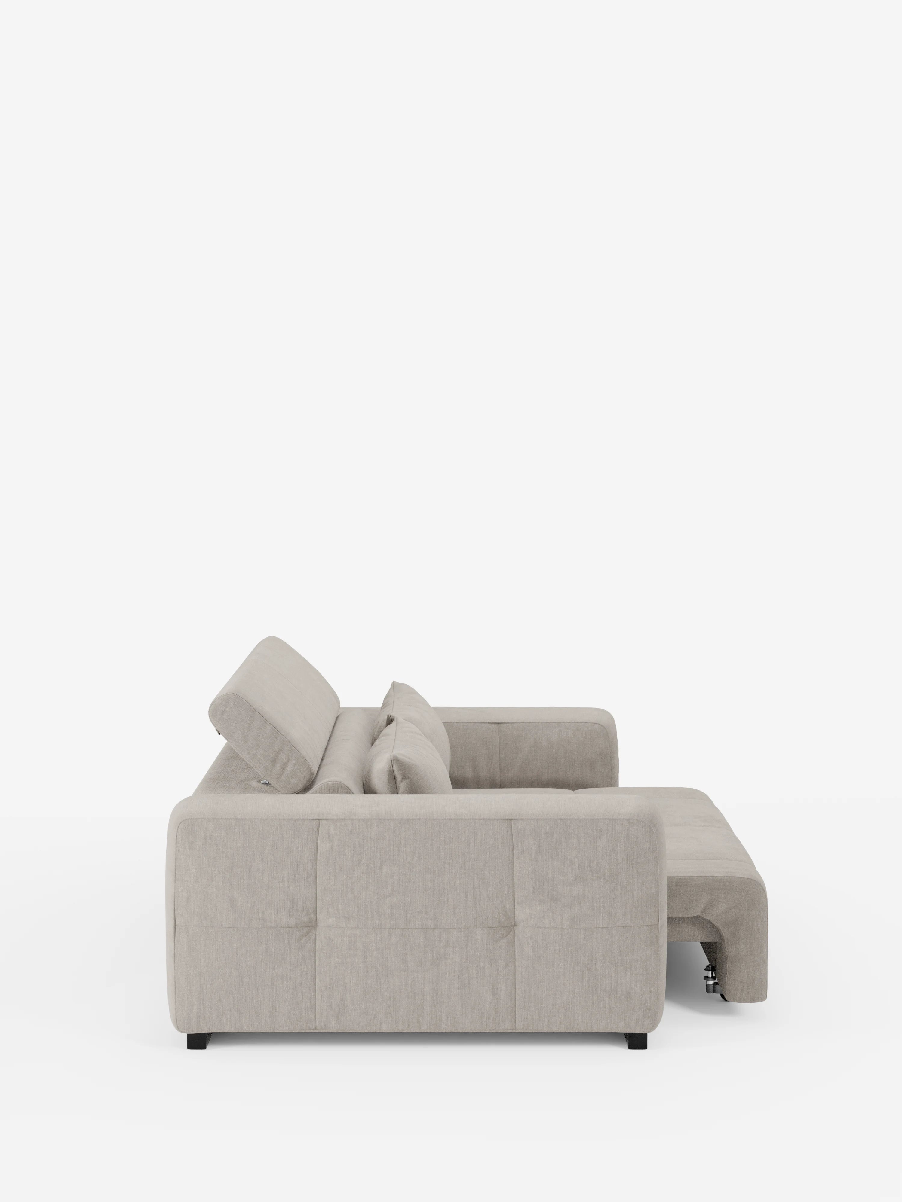 Vista laterale del divano Monarch grigio chiaro con relax elettrico per l’allungamento delle sedute e poggiatesta reclinabile di Divani.Store, un divano componibile contemporaneo a forma di L rivestito in morbido tessuto smacchiabile T31, caratterizzato da fianchi trapuntati in classico stile capitonné, morbidi cuscini dello schienale e della seduta e gambe corte nere, su uno sfondo bianco a tinta unita. La sezione chaise longue si estende verso destra.