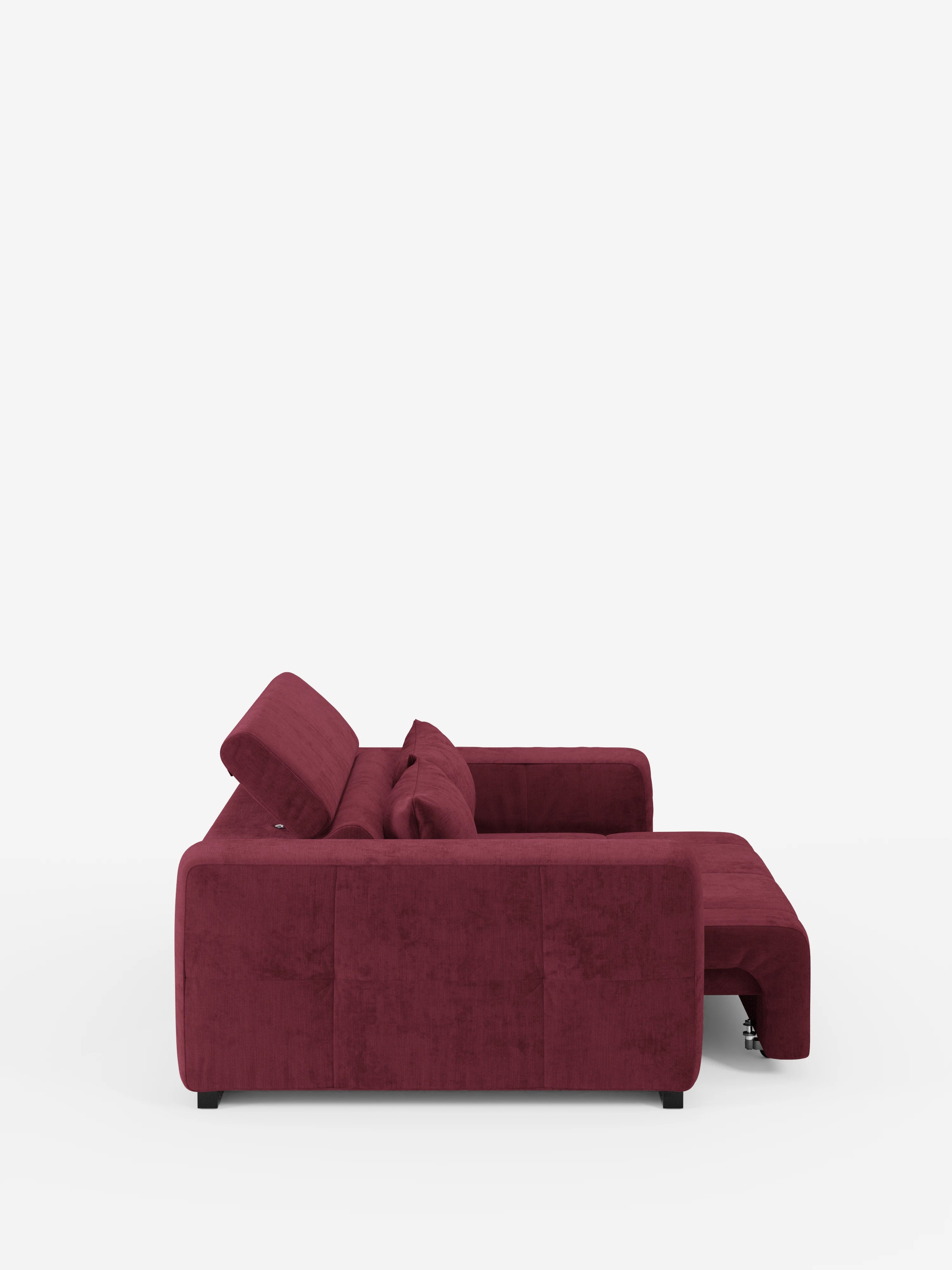 Vista laterale del “Monarch Divano con Relax Elettrico per l’allungamento delle sedute e poggiatesta reclinabile” di Divani.Store, un moderno divano componibile in color bordeaux scuro dotato di chaise longue sul lato destro. Gli schienali e i braccioli imbottiti, abbinati al rivestimento T31 liscio, morbido e resistente alle macchie, conferiscono al divano un aspetto innegabilmente elegante. Il divano poggia su gambe corte nere su uno sfondo bianco a tinta unita.