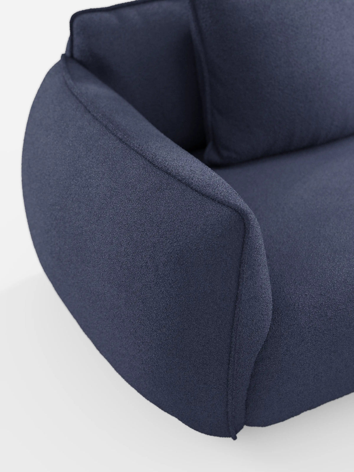 Primo piano del divano Nimbus a 3 posti, modulare e componibile, da 250 cm di Divani.Store, presentato in tessuto T33 blu scuro effetto cotone, resistente alle macchie. L’immagine mostra solo il bracciolo, la seduta e parte dello schienale, mettendo in risalto le sue curve morbide e arrotondate e i cuscini imbottiti e spessi su uno sfondo bianco. Il suo design modulare consente di creare diverse configurazioni di seduta.