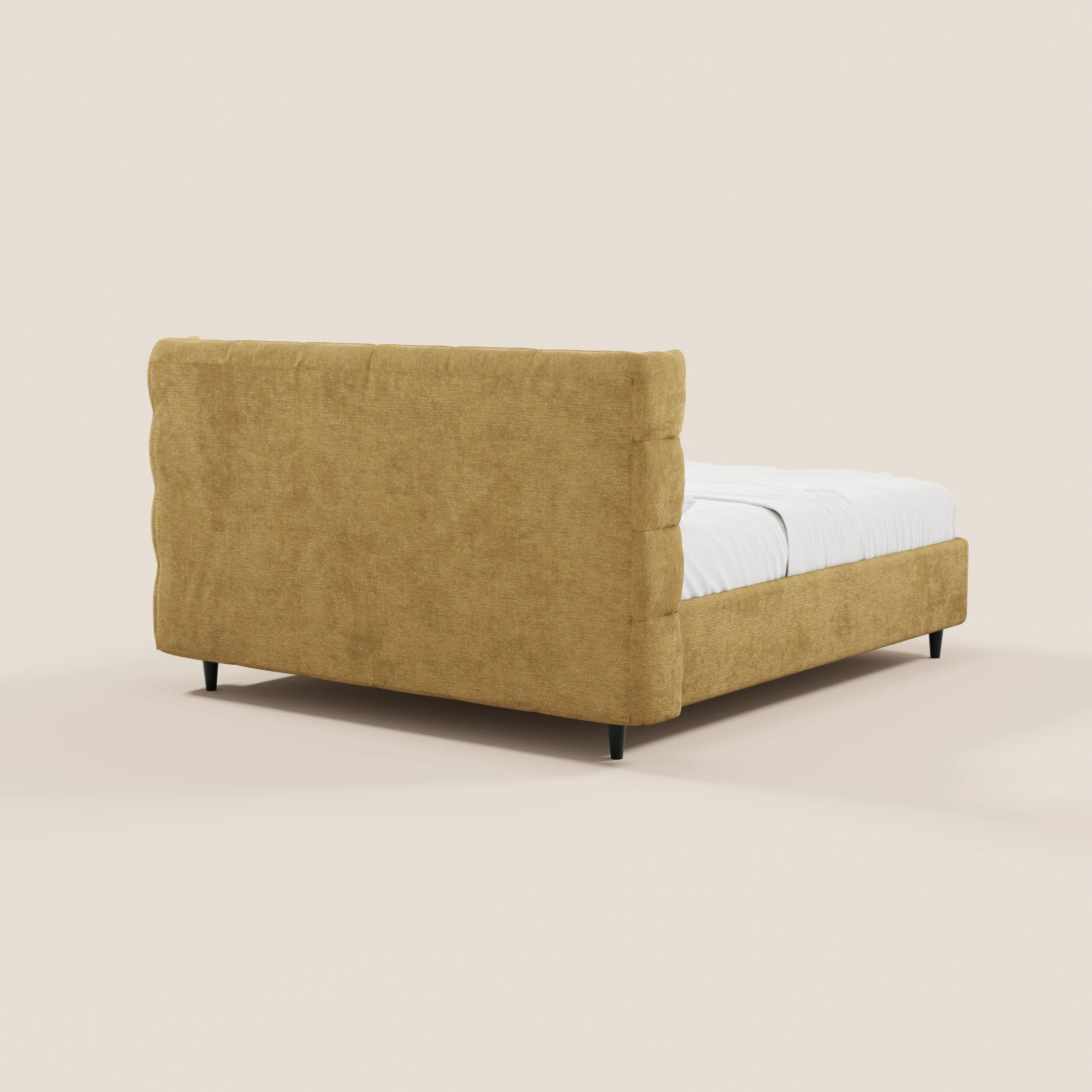 Il letto imbottito RAGNAR con contenitore e testiera capitonné avvolgente di Letti.store, in tessuto Oeko-Tex® color senape, è raffigurato di profilo con biancheria bianca e gambe nere su uno sfondo neutro.