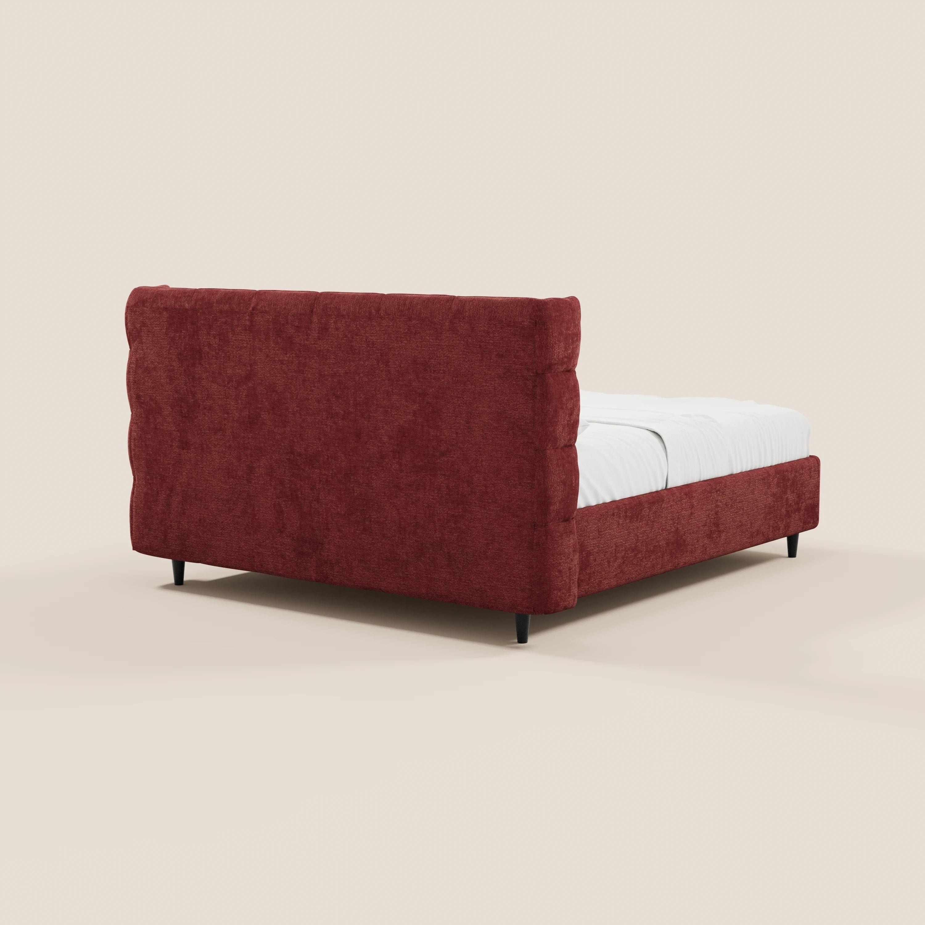 Il letto imbottito RAGNAR con contenitore di Letti.store presenta una testiera capitonné avvolgente in elegante tessuto Oeko-Tex®, una struttura moderna di colore rosso scuro, piedi neri sottili e un profilo basso, ripreso da un angolo posteriore su uno sfondo beige chiaro.